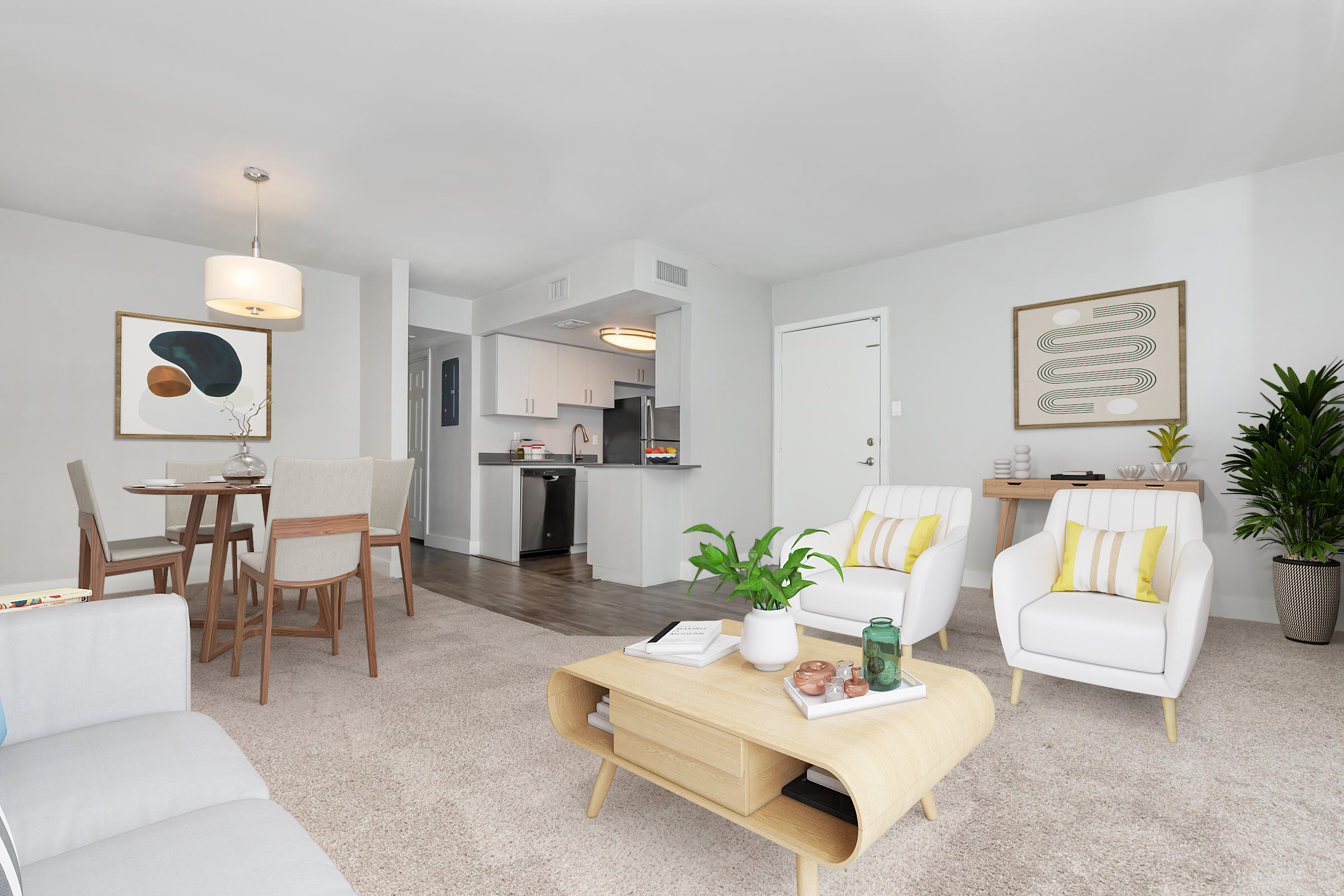 A modern, well-lit living room featuring a light gray sofa, two white armchairs with yellow accents, a round dining table with four chairs, and a kitchen visible in the background. Decorative plants and wall art add a touch of style to the space, which has a neutral color palette and a cozy atmosphere.