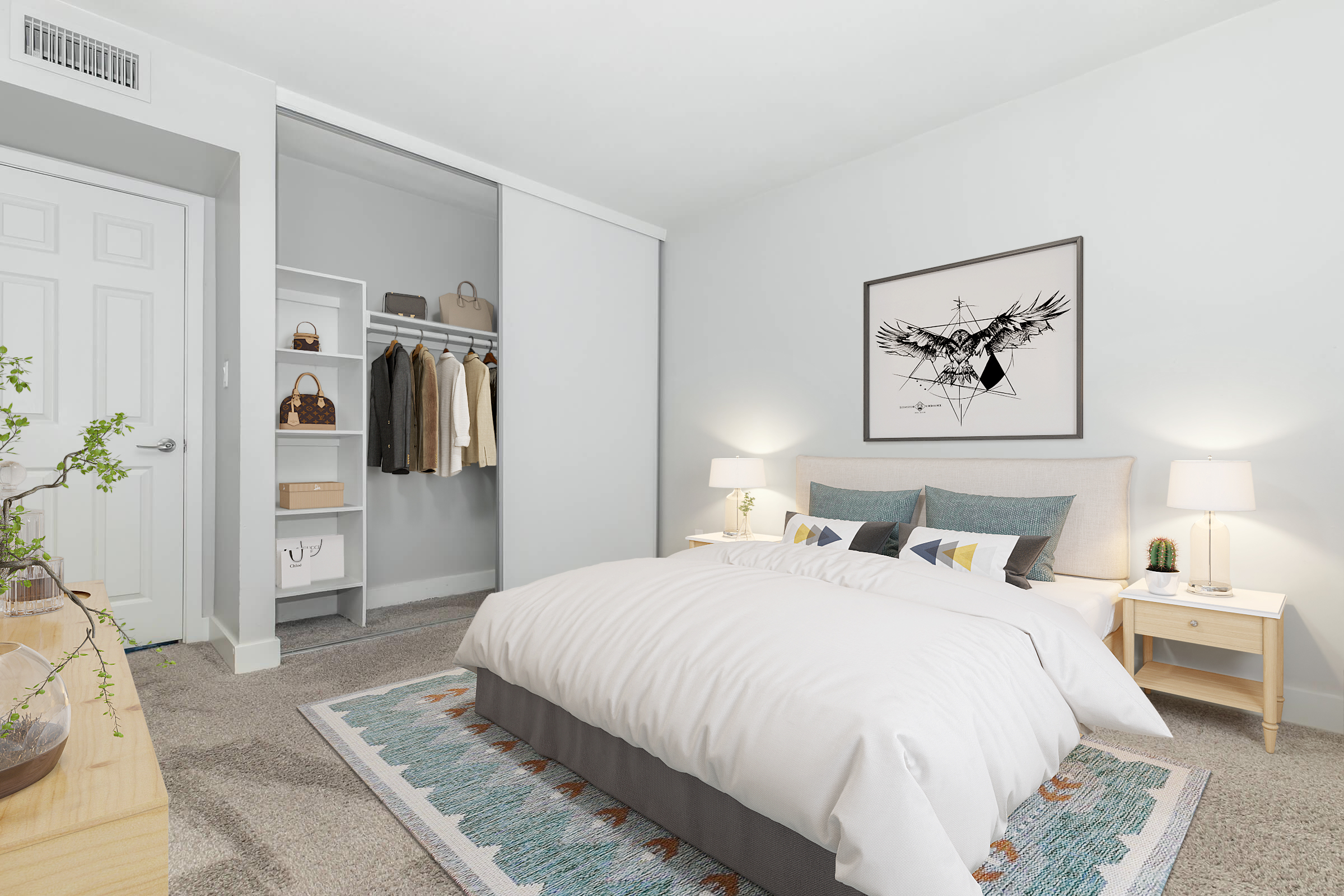 A modern bedroom featuring a cozy bed with white bedding and decorative pillows. On either side of the bed, there are bedside tables with lamps. A spacious closet is seen in the background with clothes hanging. The room has neutral colored walls and a patterned rug on the floor, creating a stylish and inviting atmosphere.