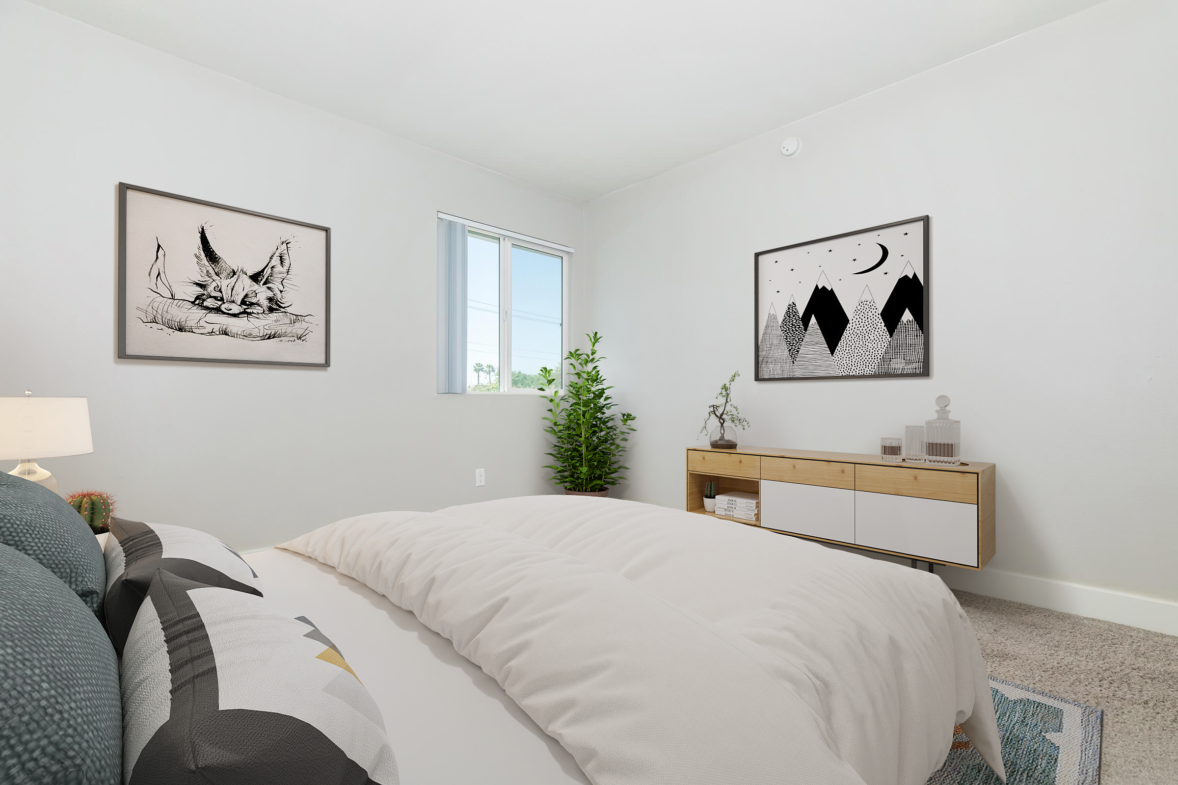 Modern bedroom featuring a bed with a light comforter, decorative pillows, and two framed artworks on the walls. A window allows natural light in, and a green plant adds a touch of nature. A sleek wooden sideboard with minimal decor completes the cozy atmosphere.