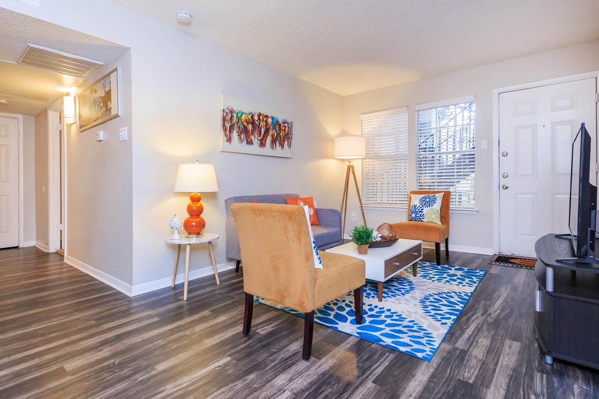 a living room filled with furniture on top of a hard wood floor