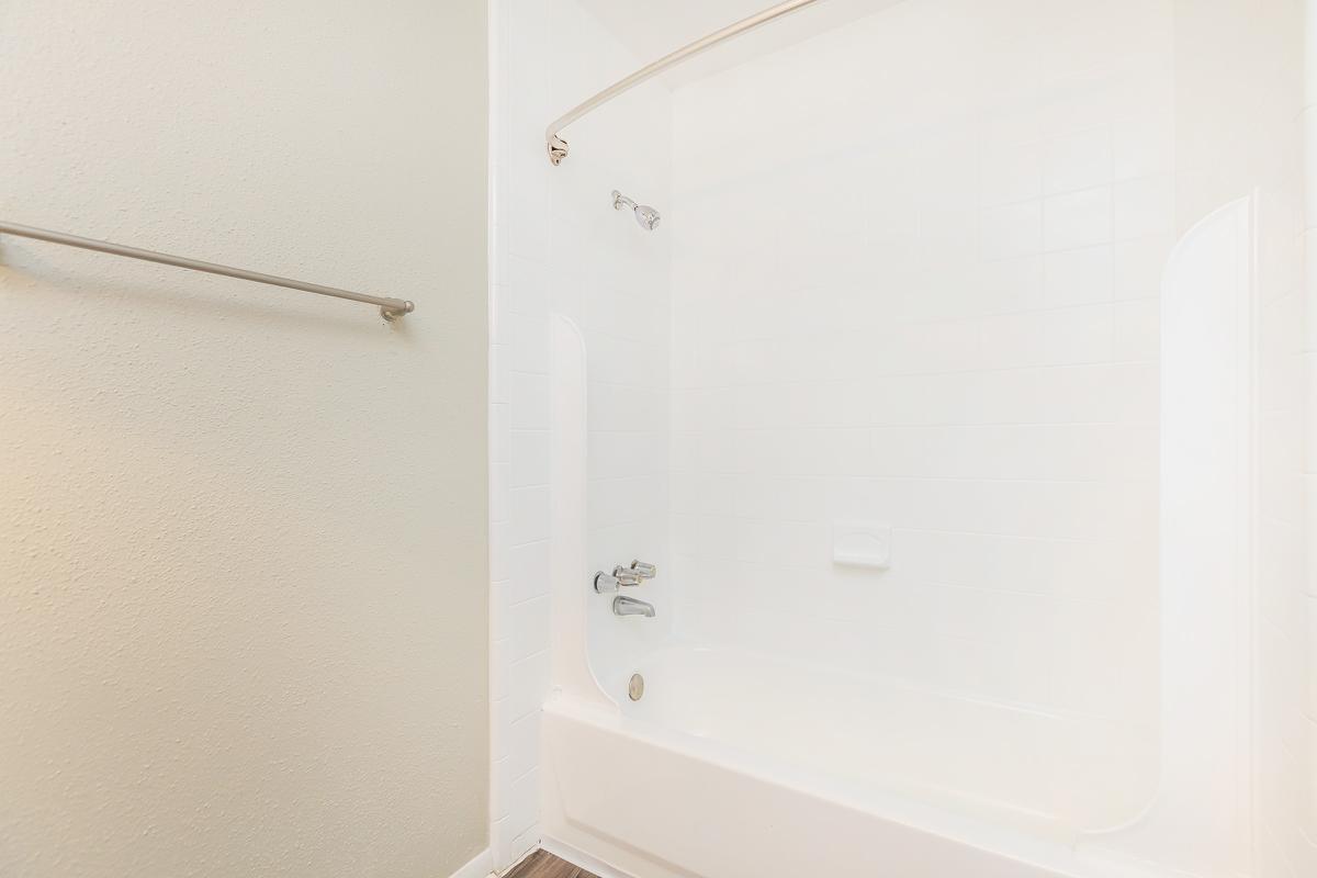 a white tub sitting next to a shower