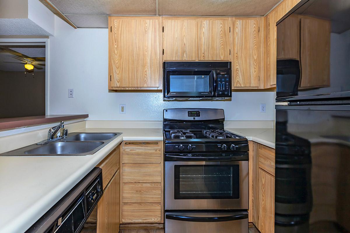 a kitchen with wooden cabinets and a black stove top oven