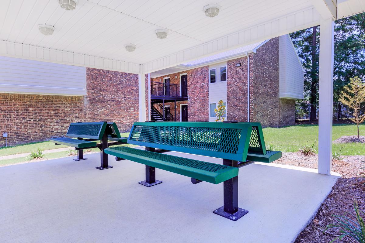 an empty park bench sitting in front of a building