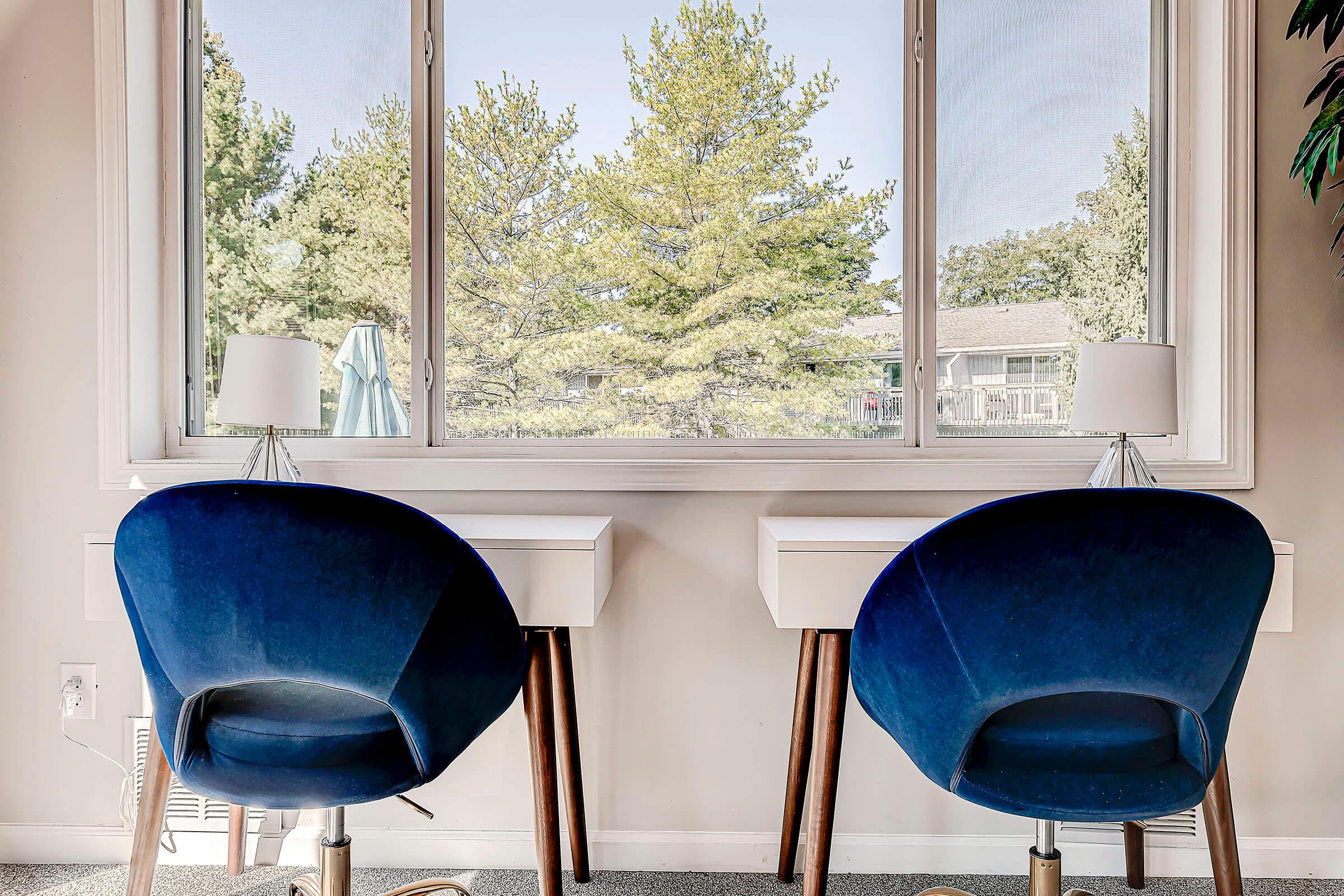 a blue chair sitting in front of a window