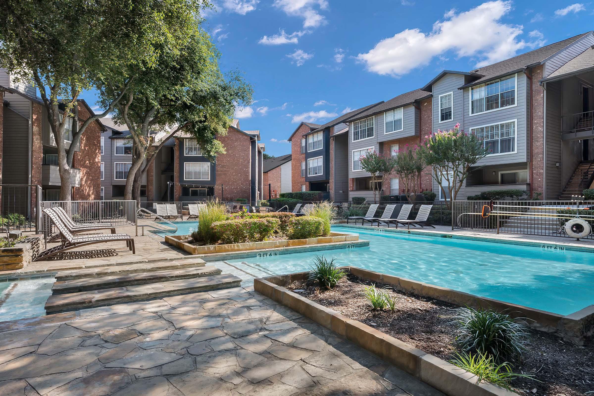 a house with a pool in front of a brick building