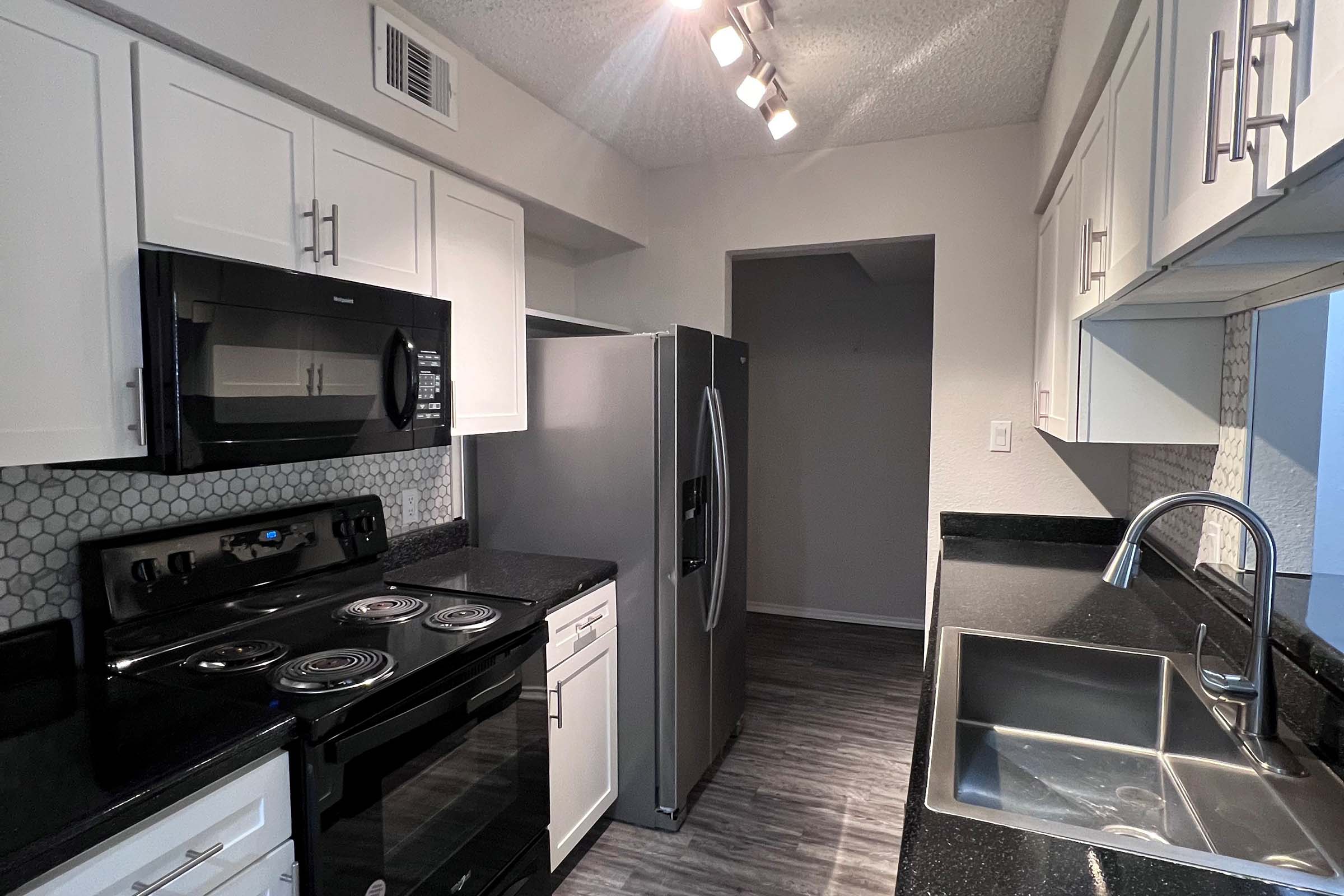 a stove top oven sitting inside of a kitchen with stainless steel appliances