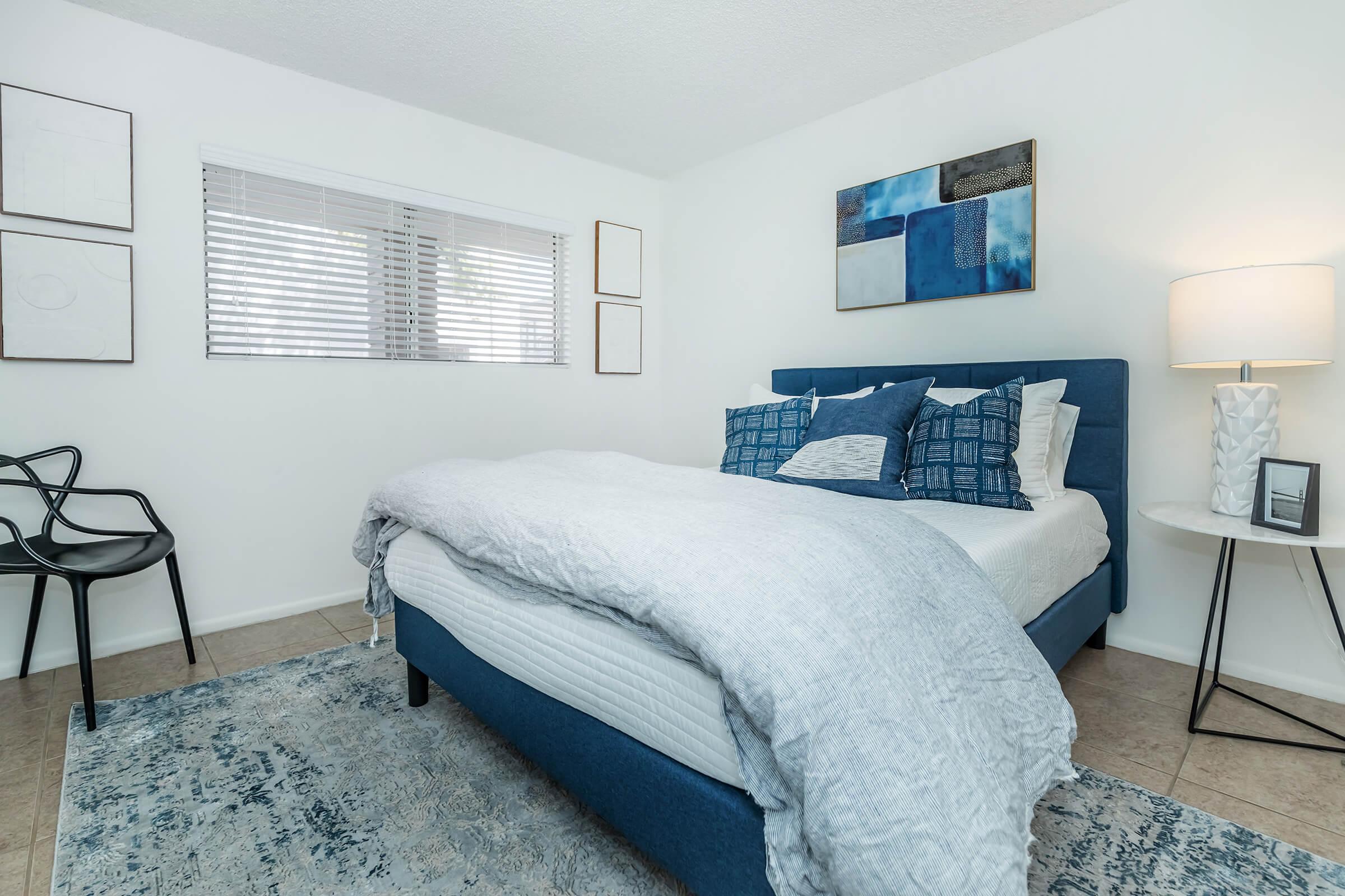 a bedroom with a bed and desk in a room