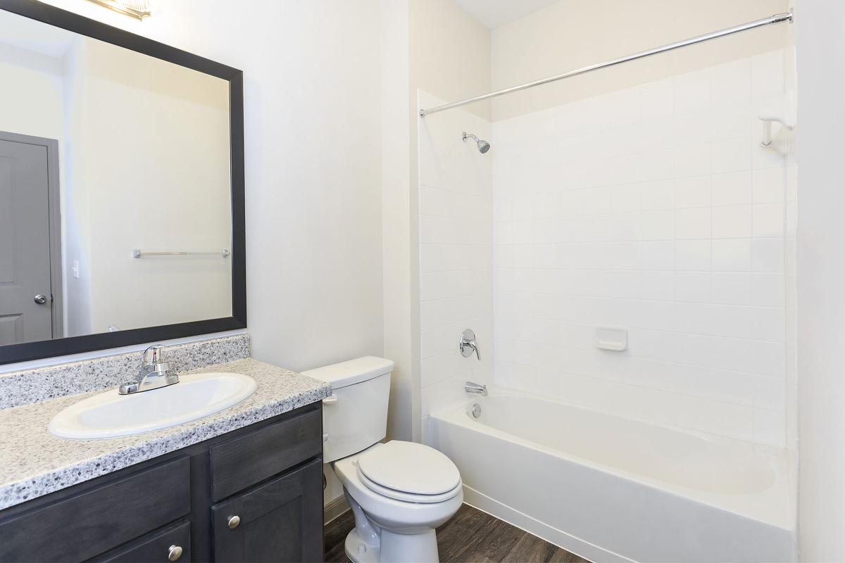 a white sink sitting next to a shower