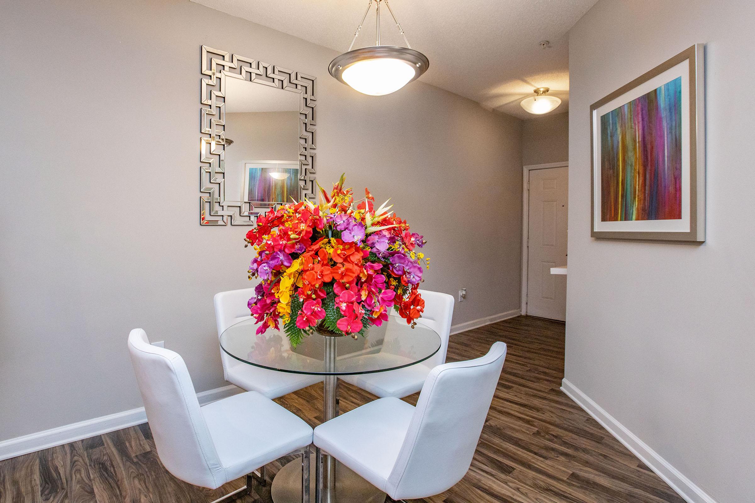 a living room filled with furniture and vase of flowers on a table