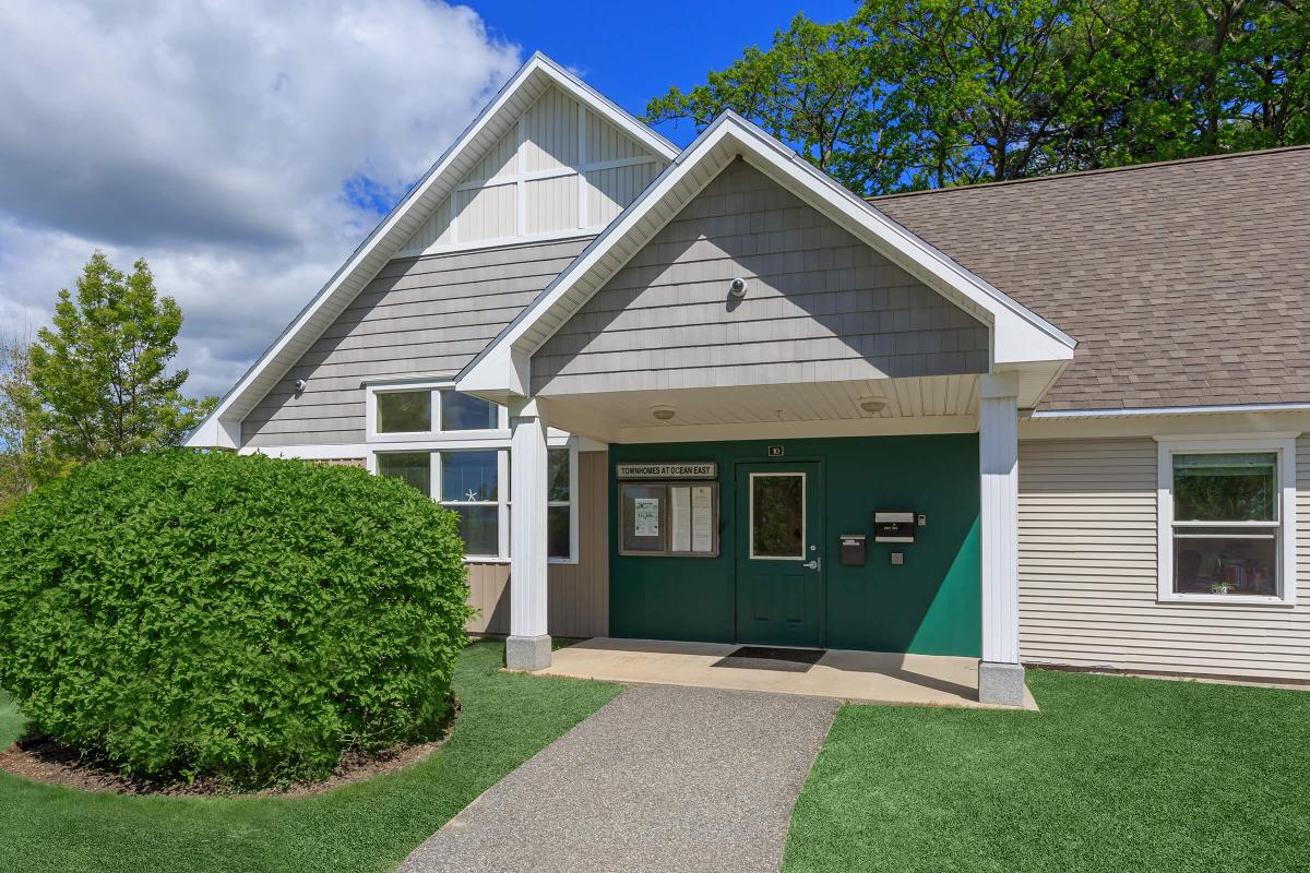 a large brick building with green grass in front of a house