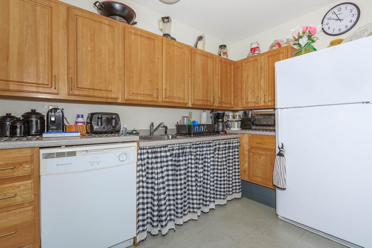 a kitchen with white appliances and wooden cabinets