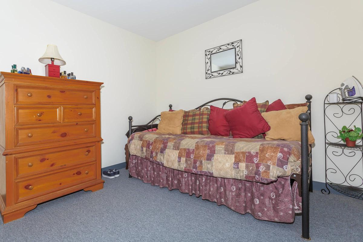 a bedroom with a bed and desk in a small room