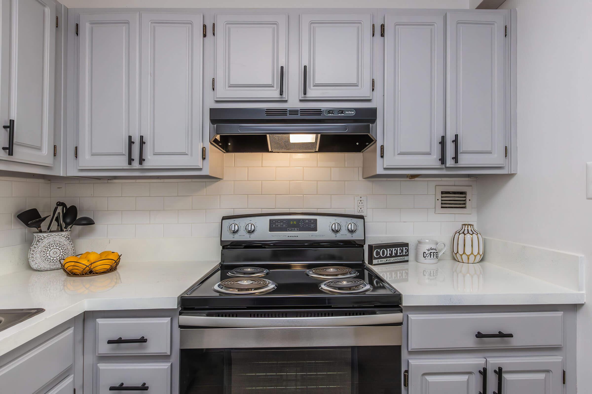 a stove top oven sitting inside of a kitchen