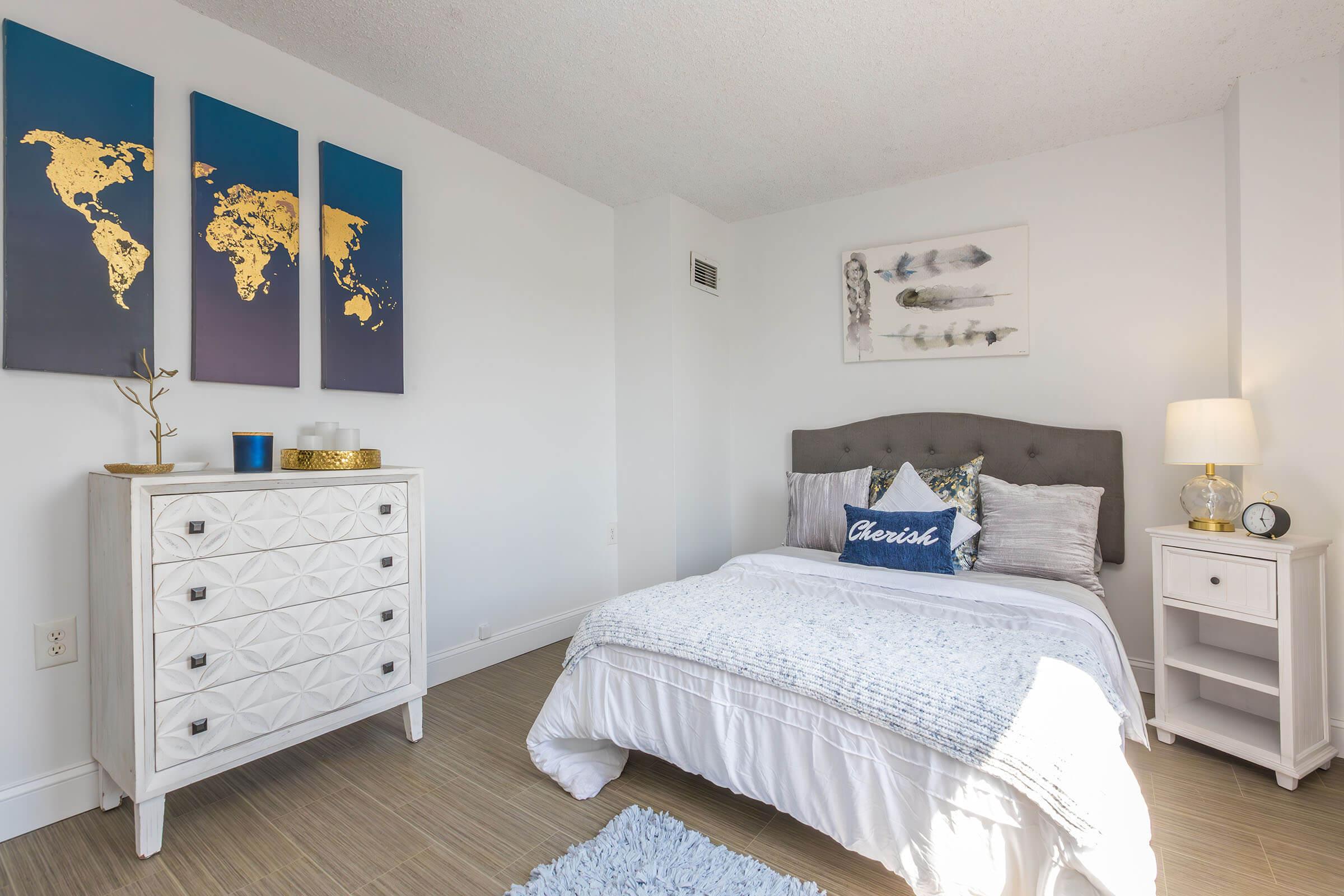 a bedroom with a bed and desk in a room