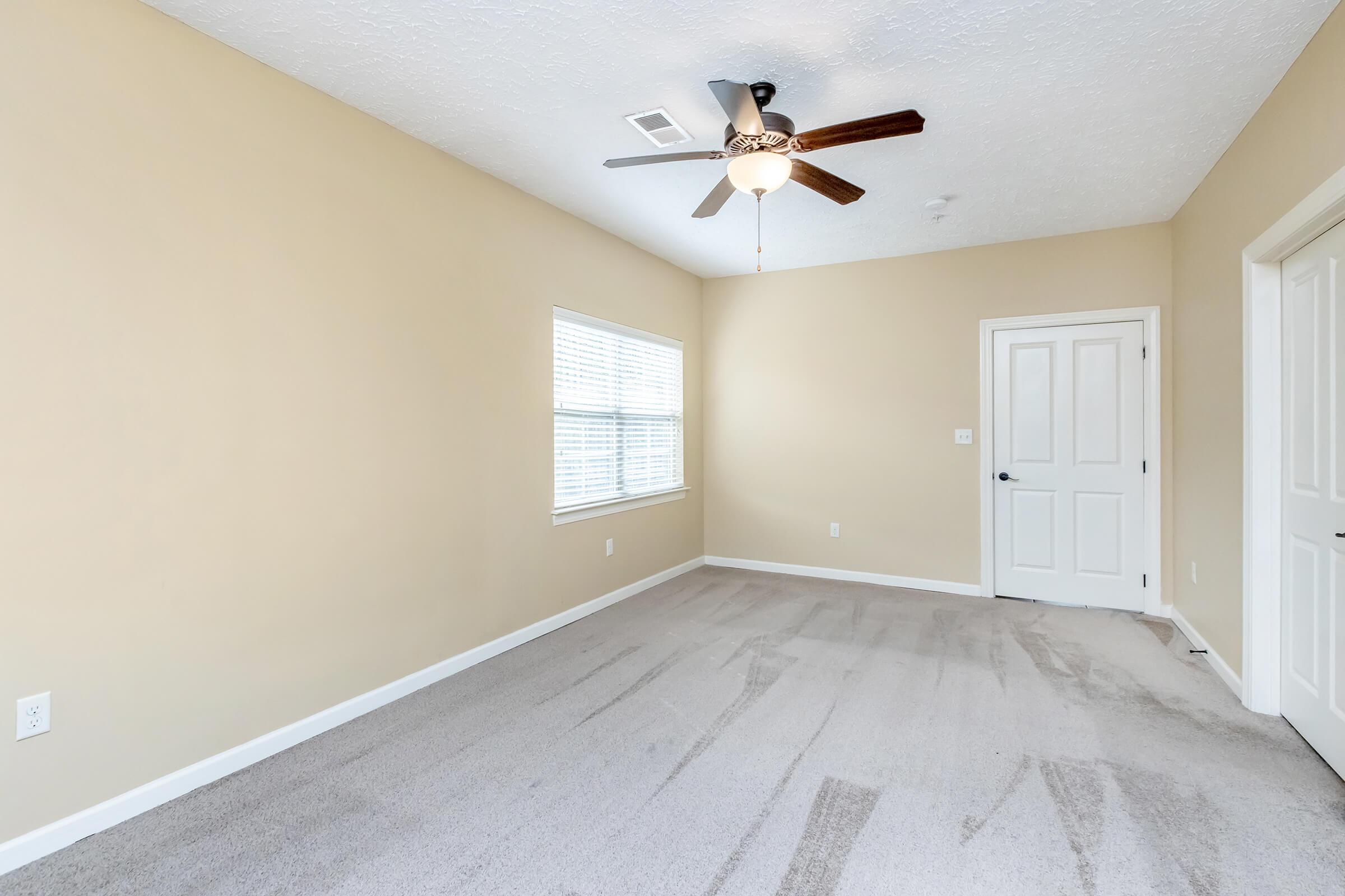 bedroom with carpeting, large window and closet door