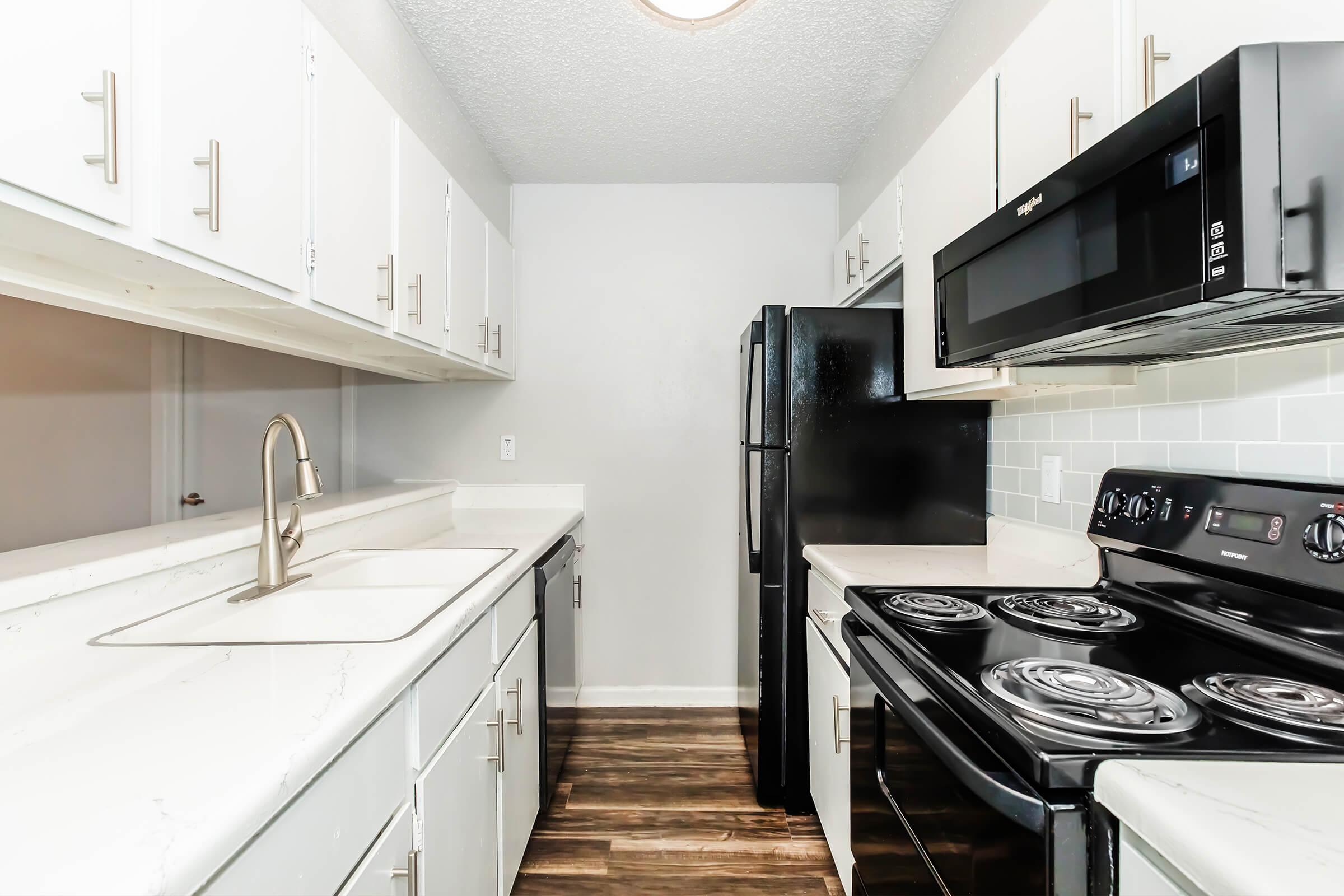 a stove top oven sitting inside of a kitchen with stainless steel appliances