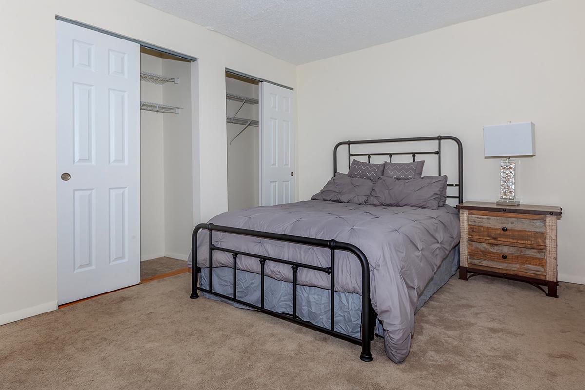 a bedroom with a bed and desk in a room