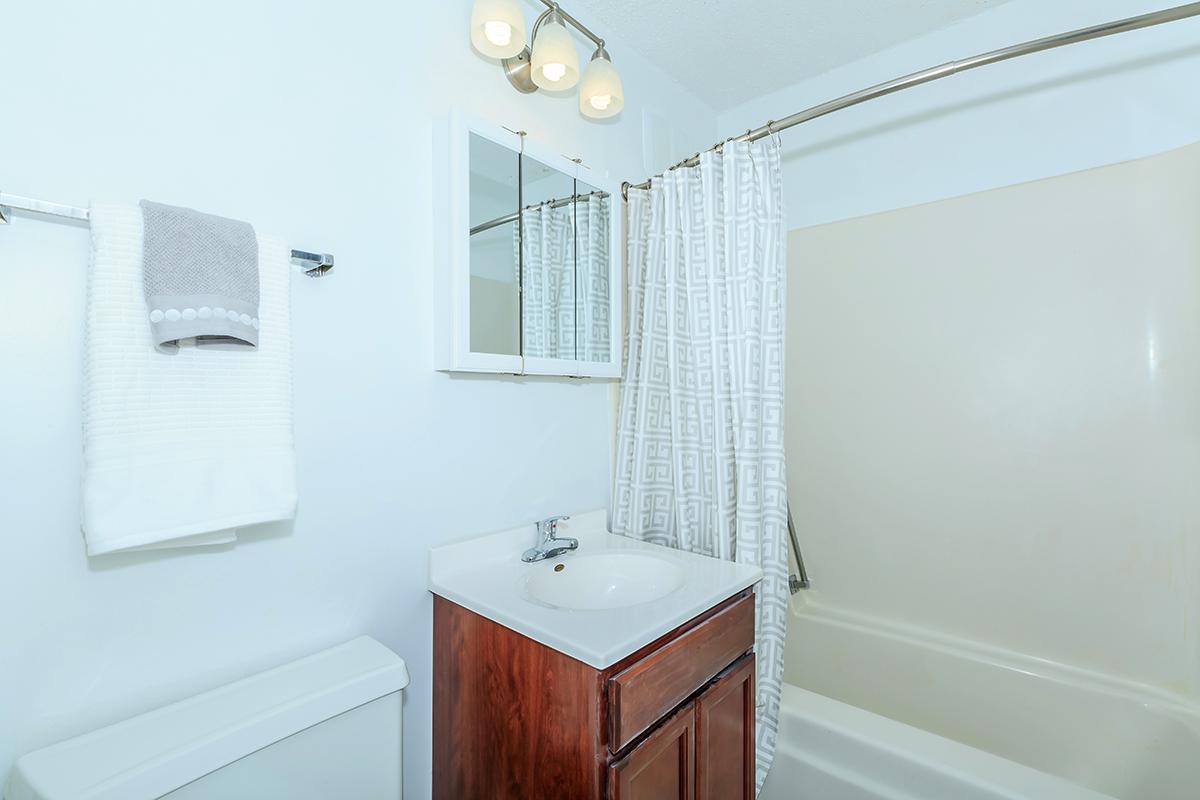 a white sink sitting next to a shower