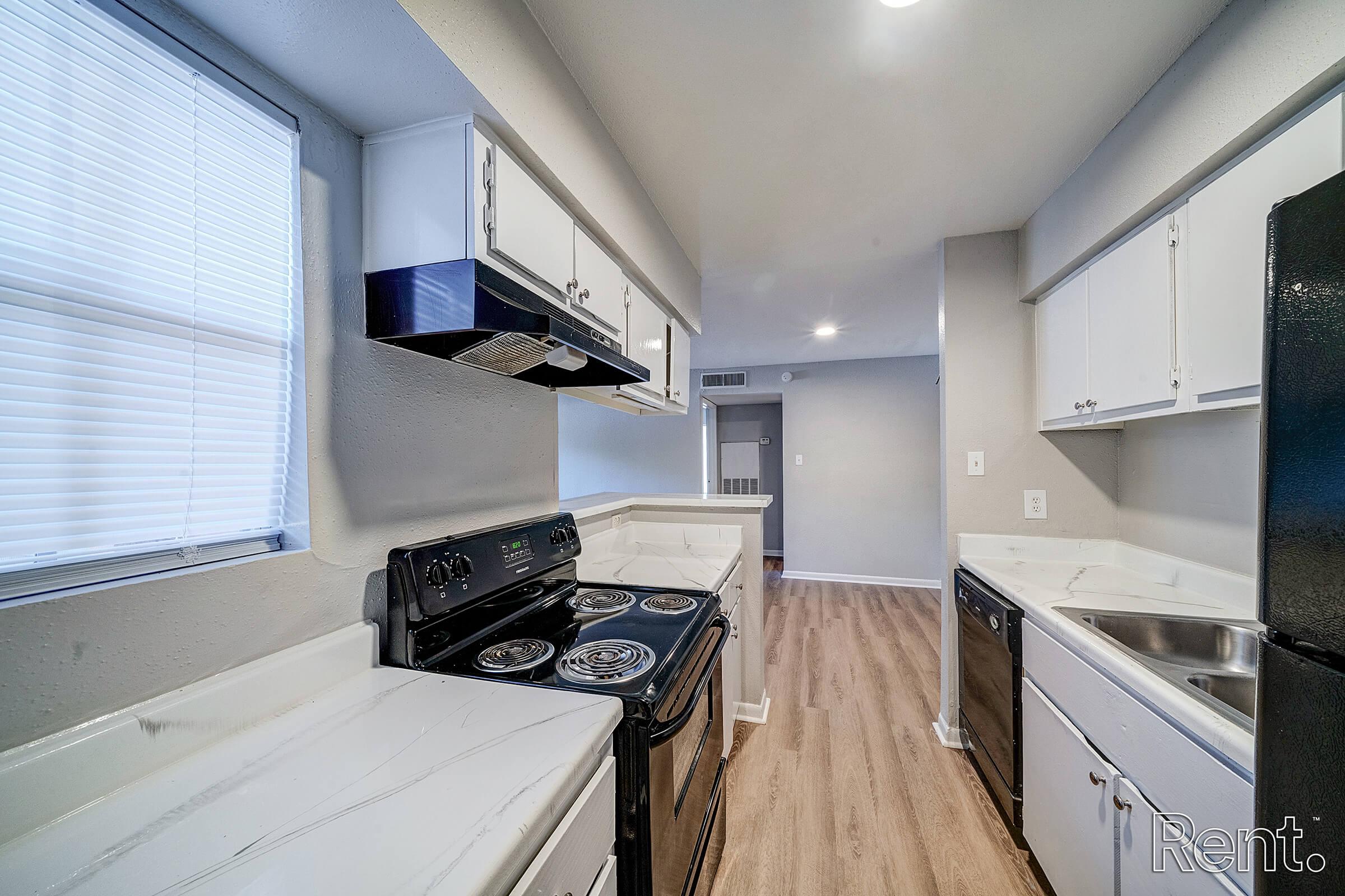 a kitchen with a stove a sink and a window