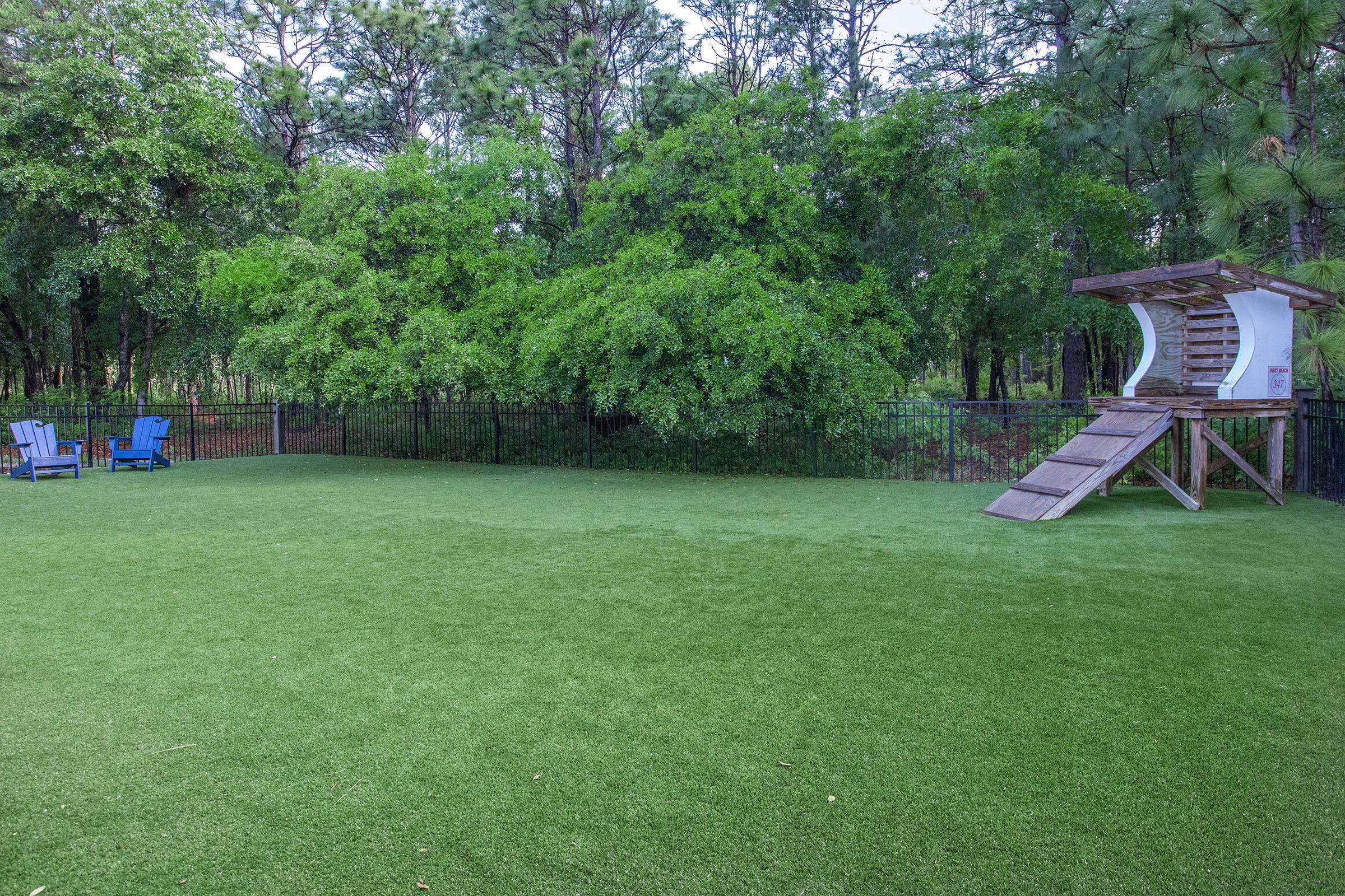 a couple of lawn chairs sitting on top of a lush green field