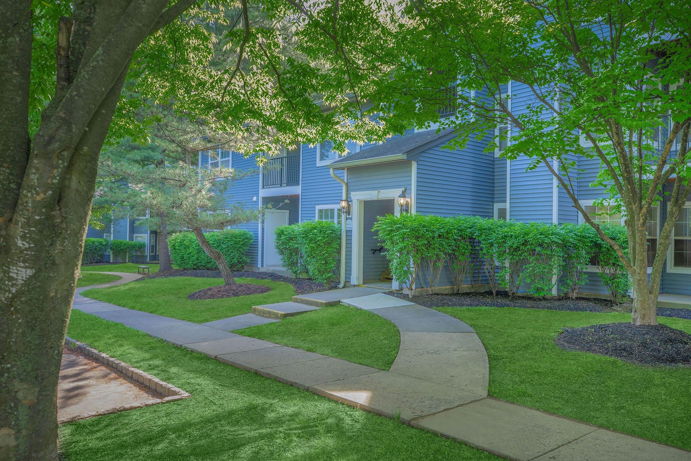 a path with trees on the side of a building