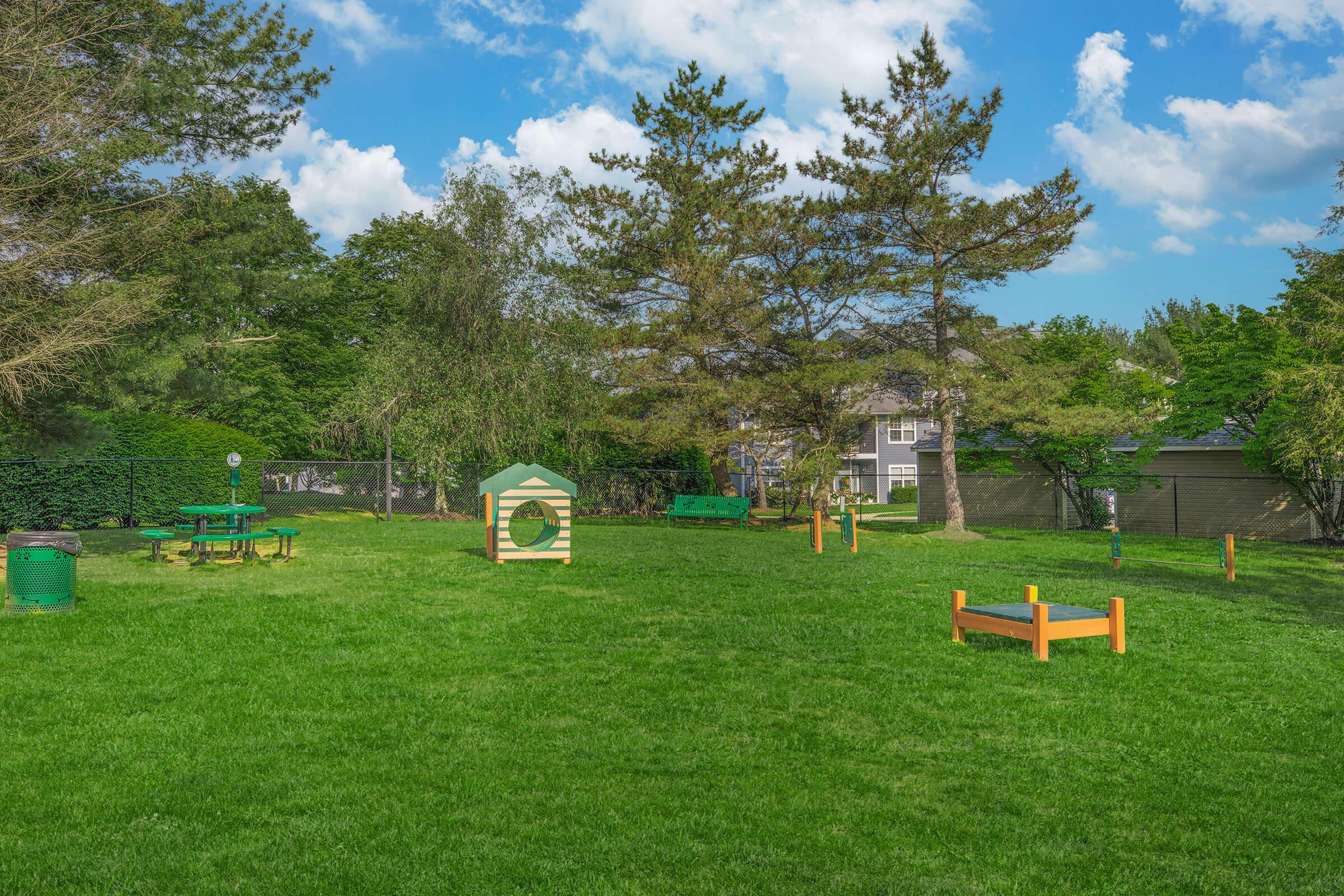 a large green field with trees in the background