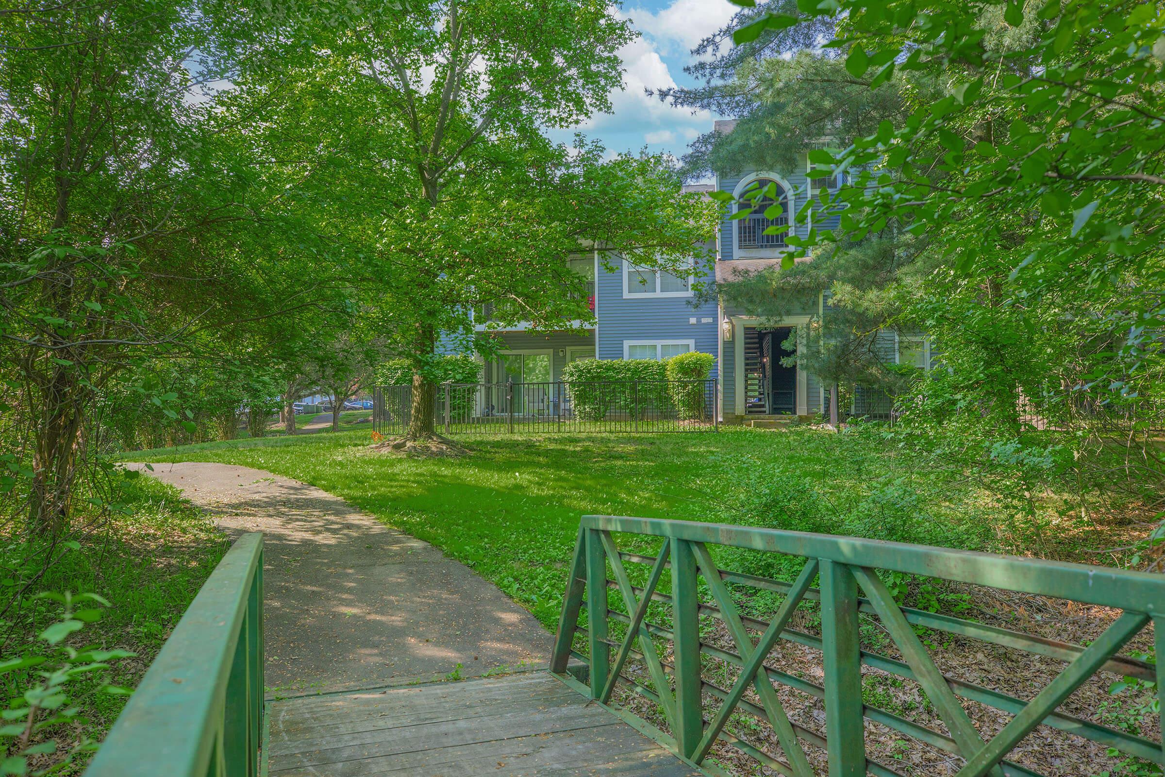 a green bench sitting in front of a tree