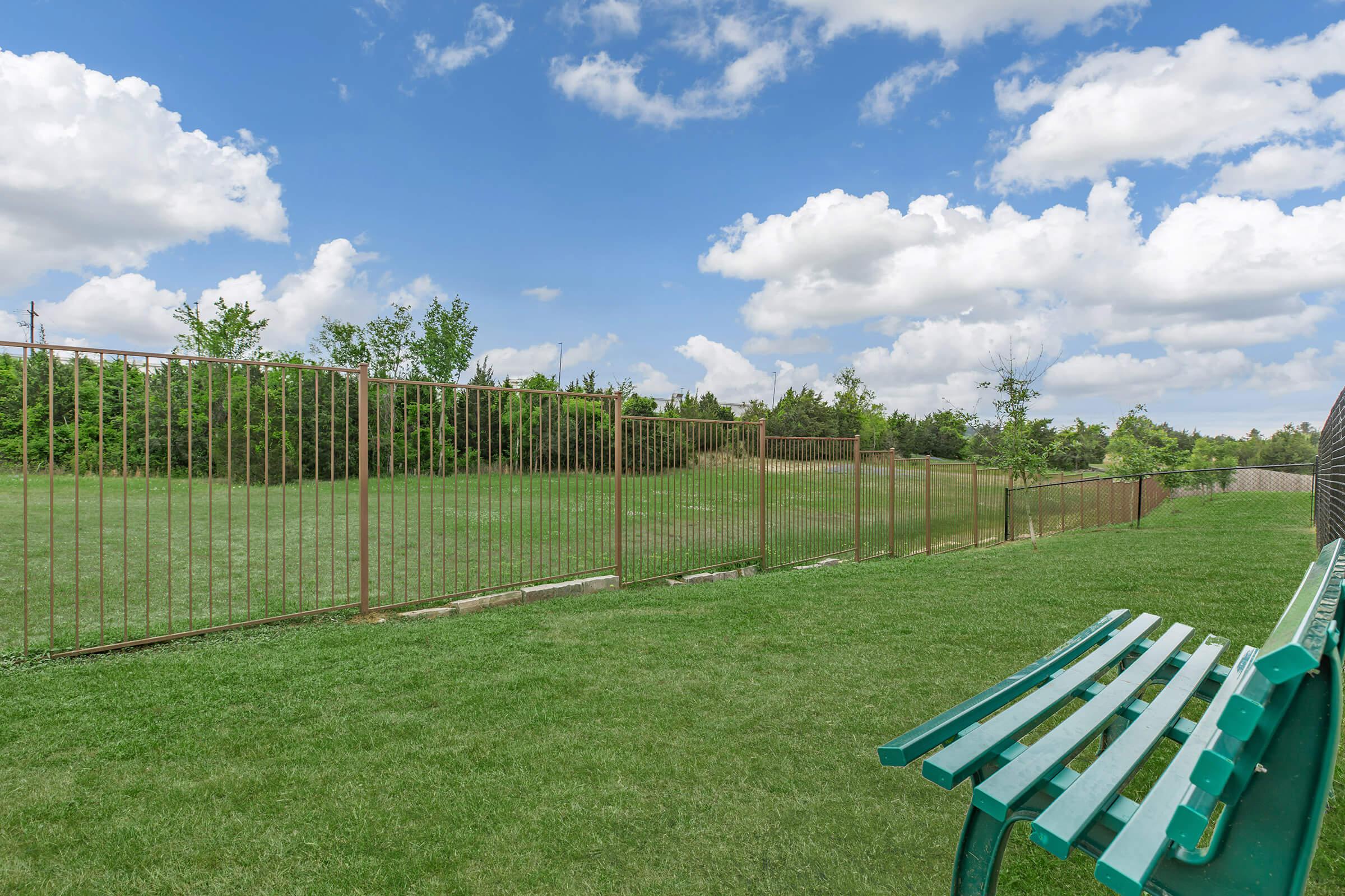 a wooden bench sitting on top of a grass covered field