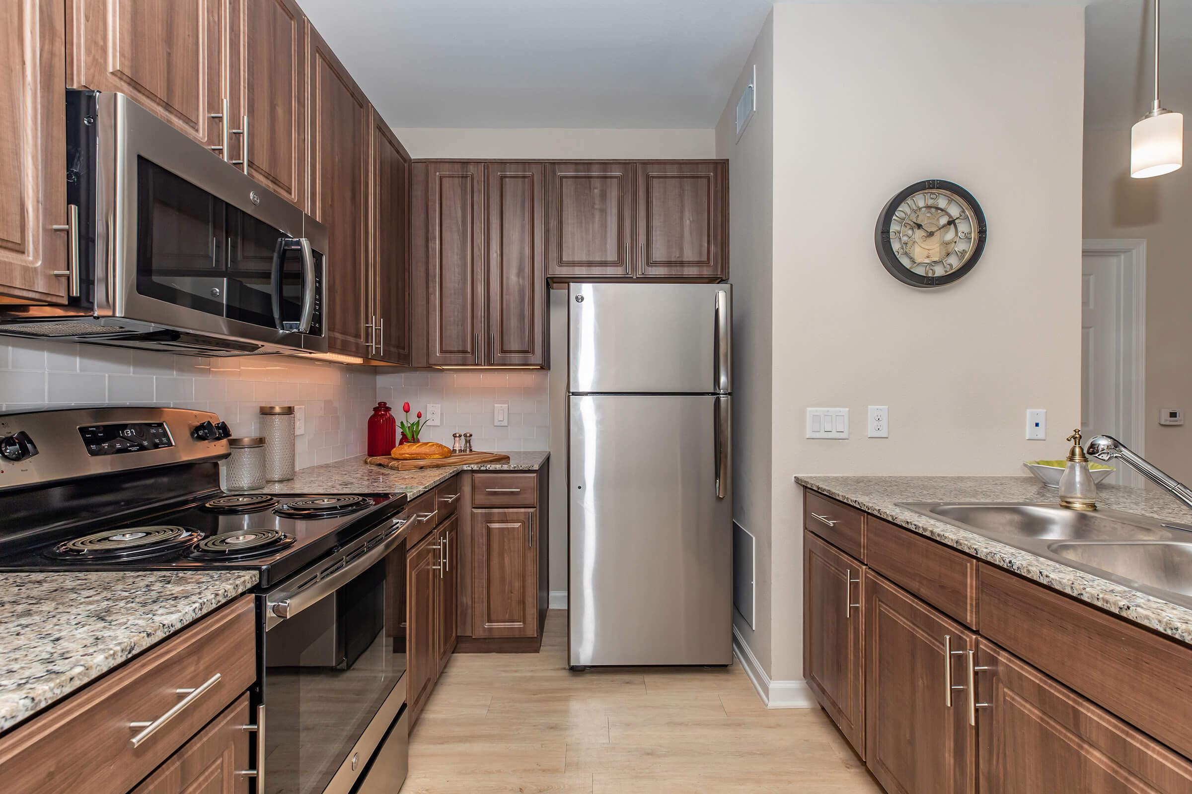 a large kitchen with stainless steel appliances and wooden cabinets