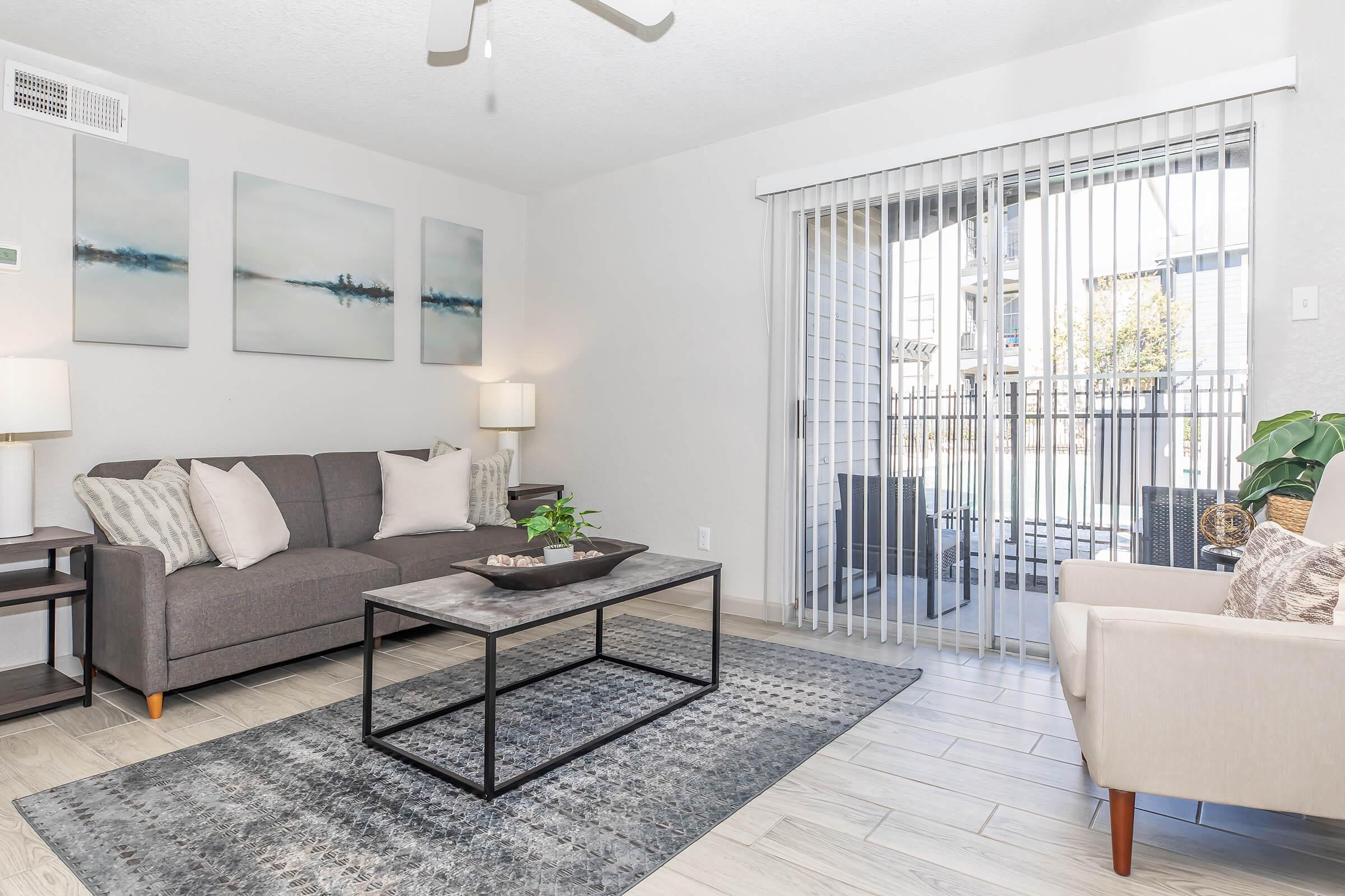 a living room filled with furniture and a large window