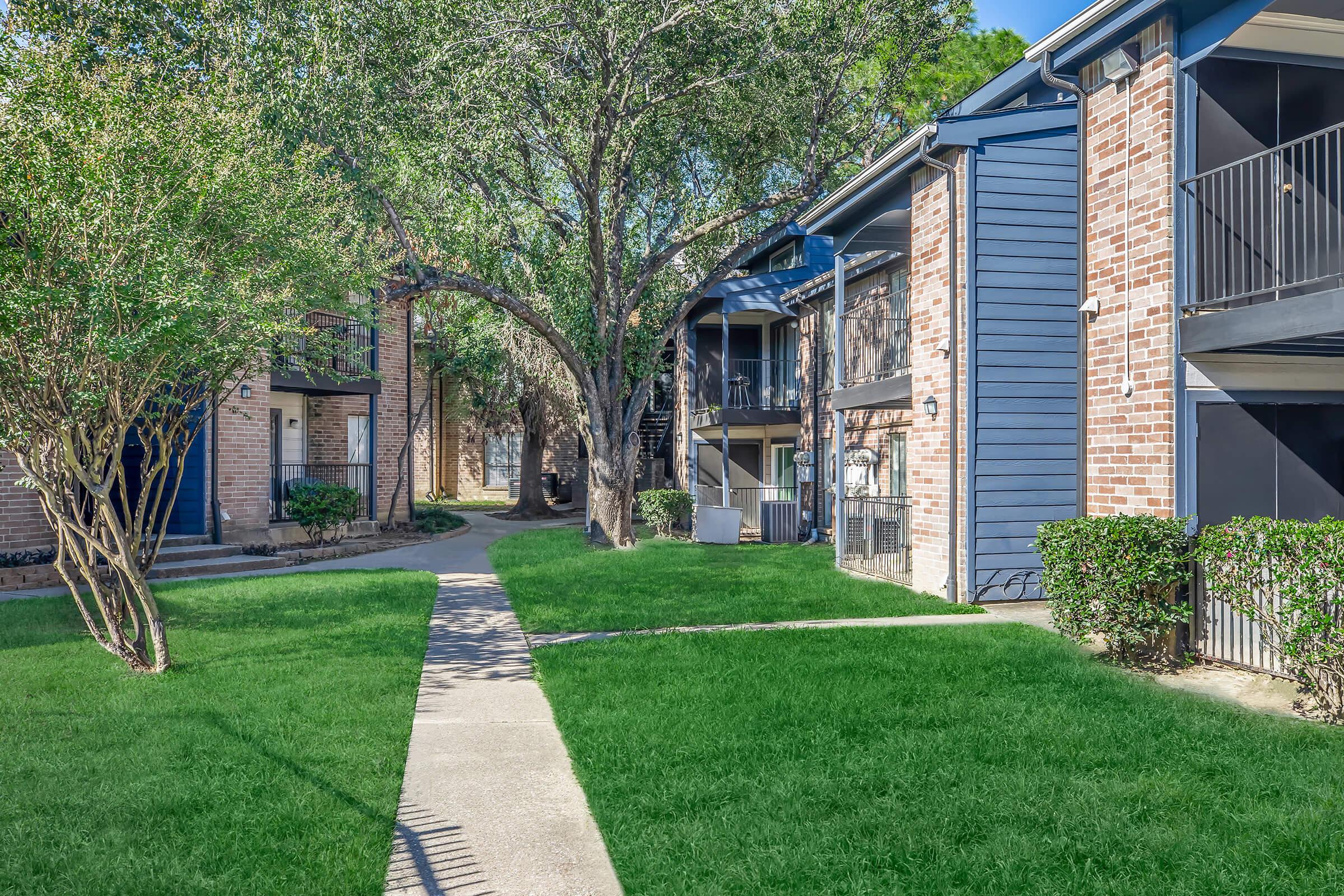 a house with a lawn in front of a brick building