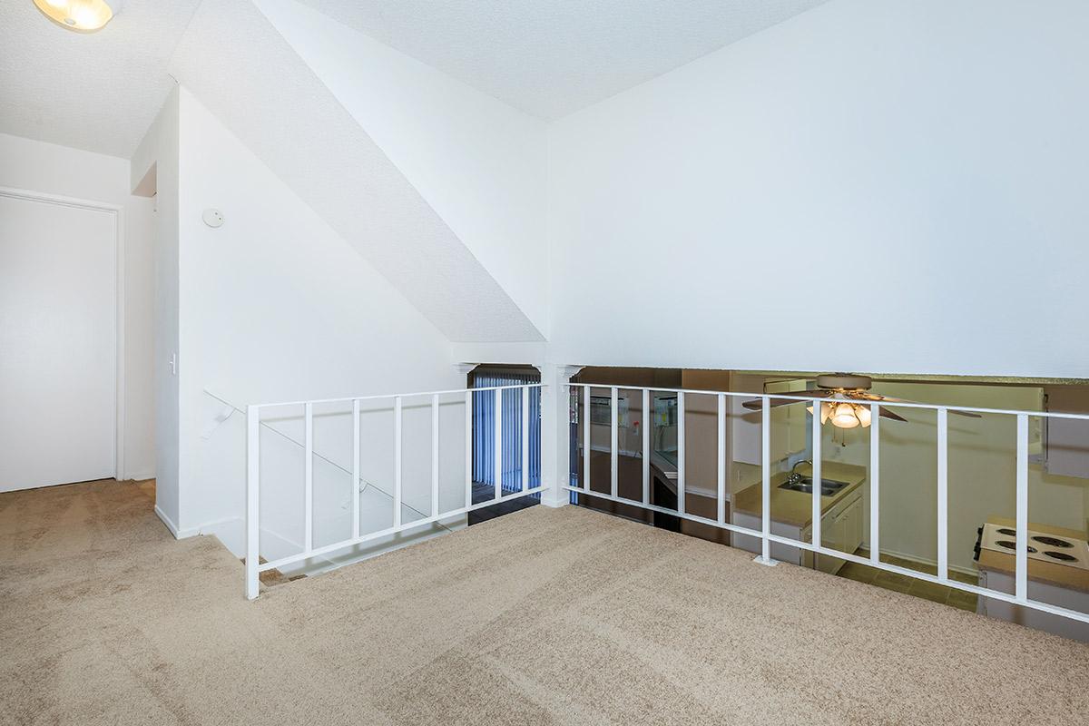 Carpeted room with white railing