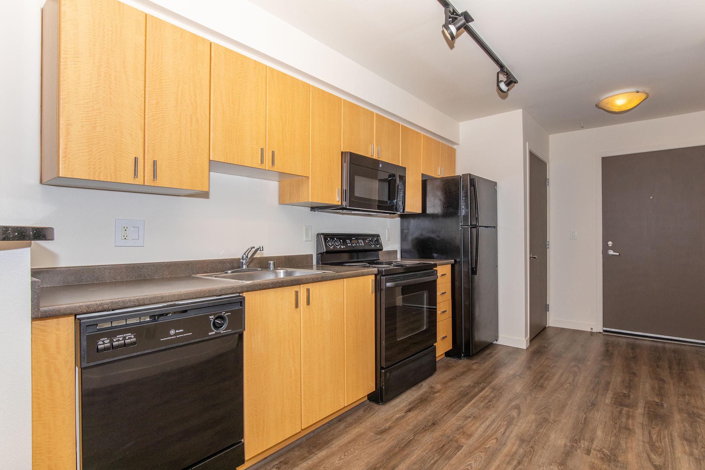 a large kitchen with stainless steel appliances and wooden cabinets