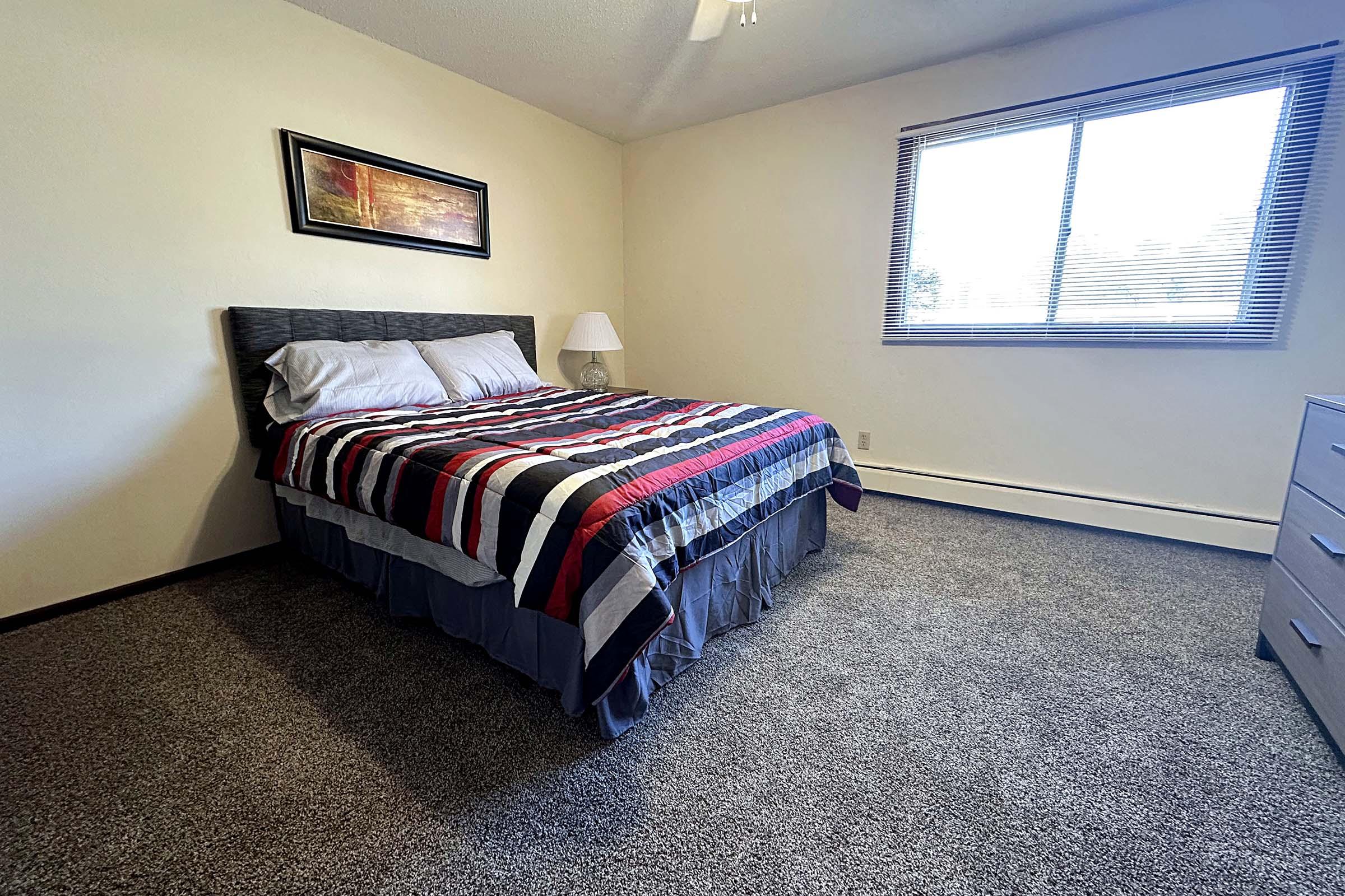 a bedroom with a bed and desk in a room