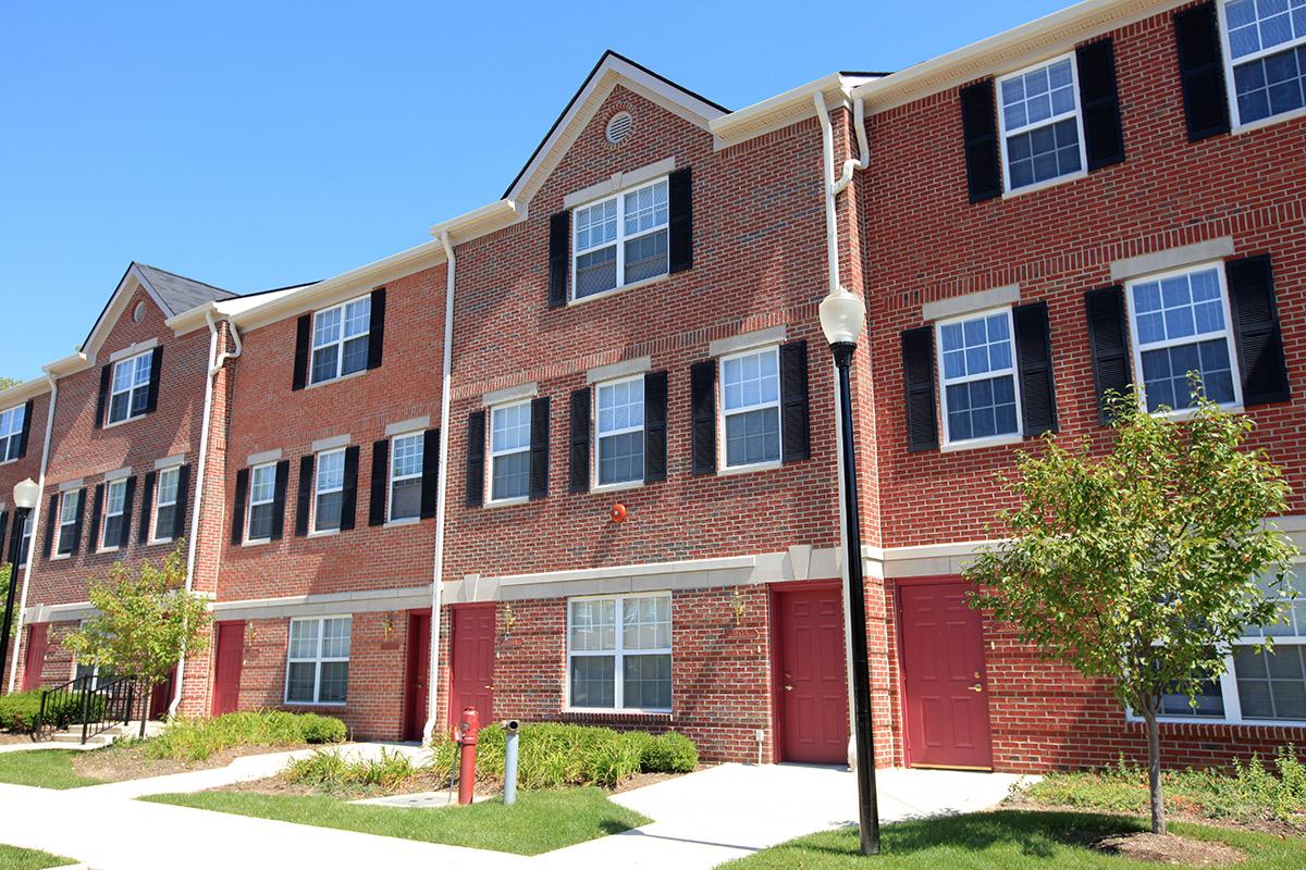 a large brick building with grass in front of a house