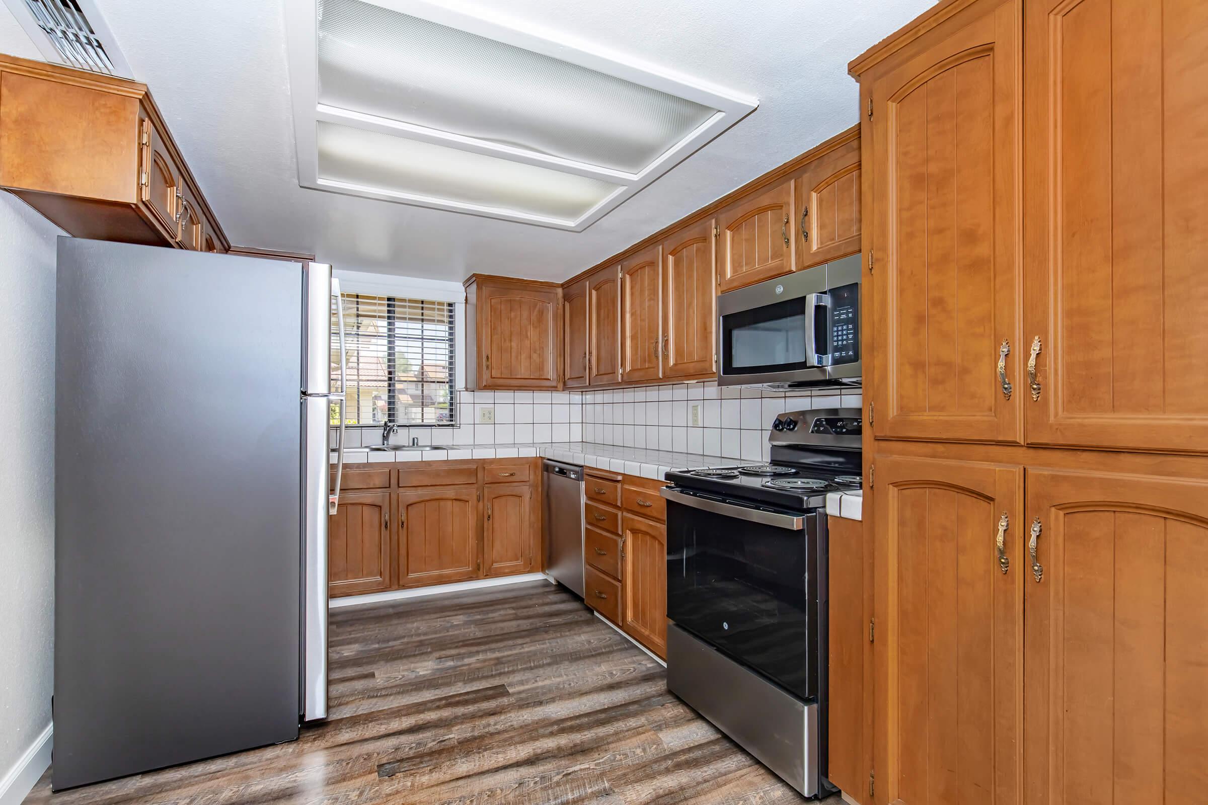 a large kitchen with stainless steel appliances and wooden cabinets