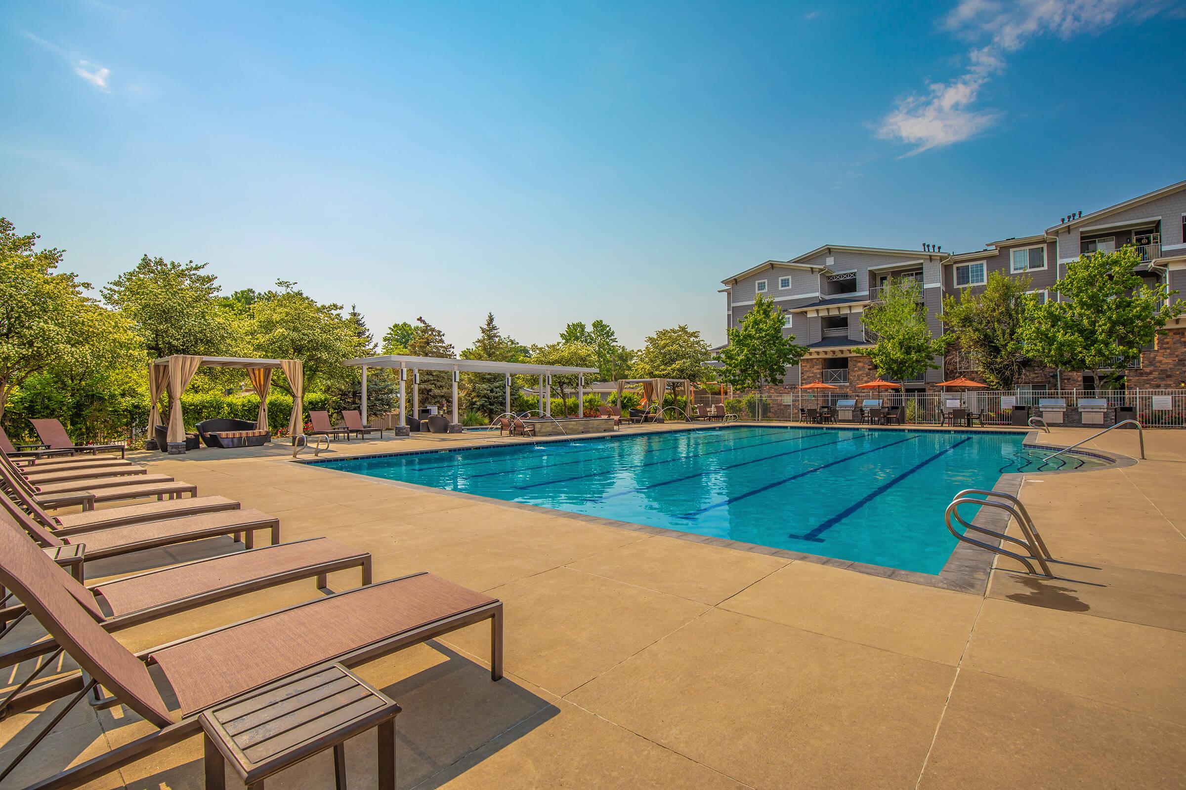 a row of lawn chairs sitting next to a pool of water