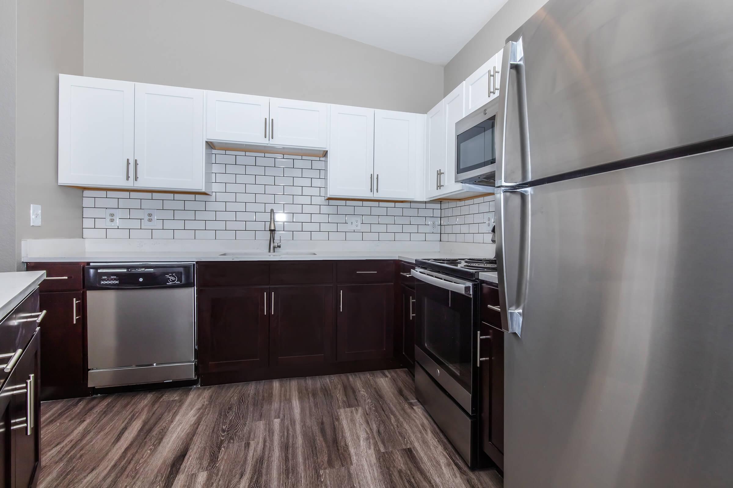 a large kitchen with stainless steel appliances and wooden cabinets