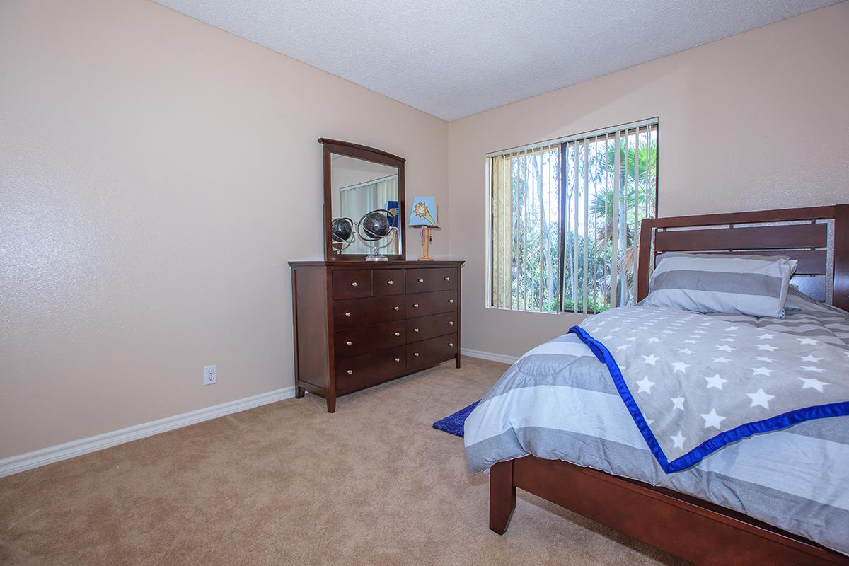 a bedroom with a bed and desk in a room