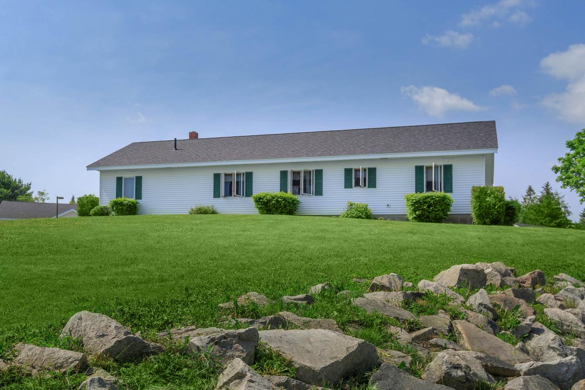 a herd of sheep grazing in front of a house