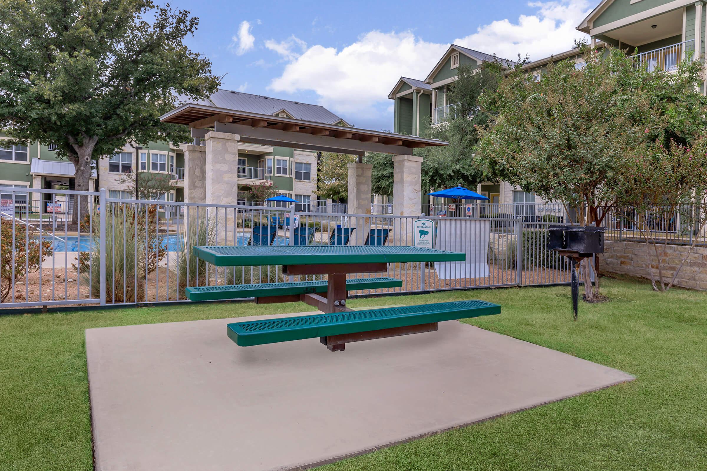 a green park bench sitting in front of a building