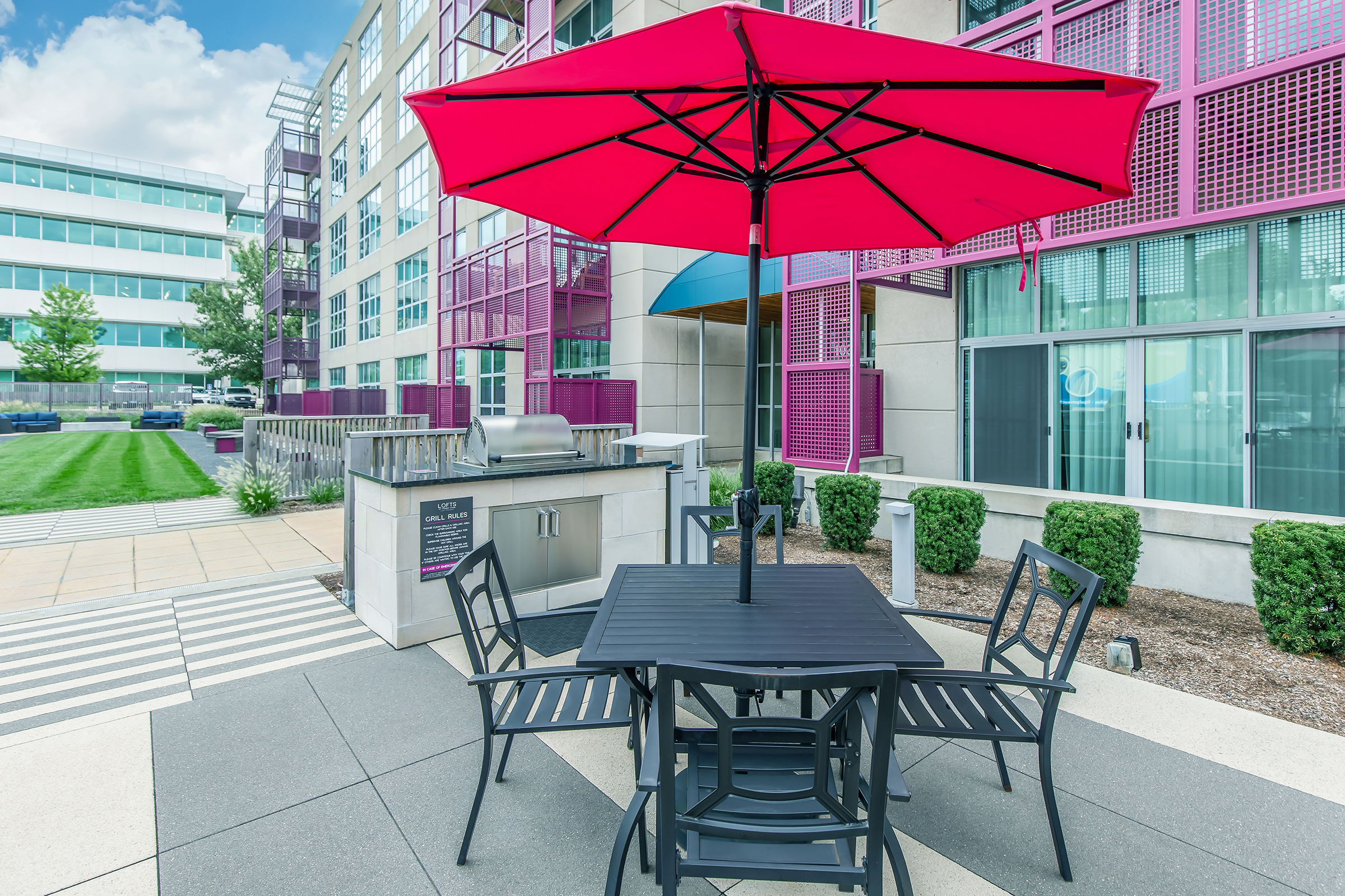 a chair sitting in front of a building with a green umbrella