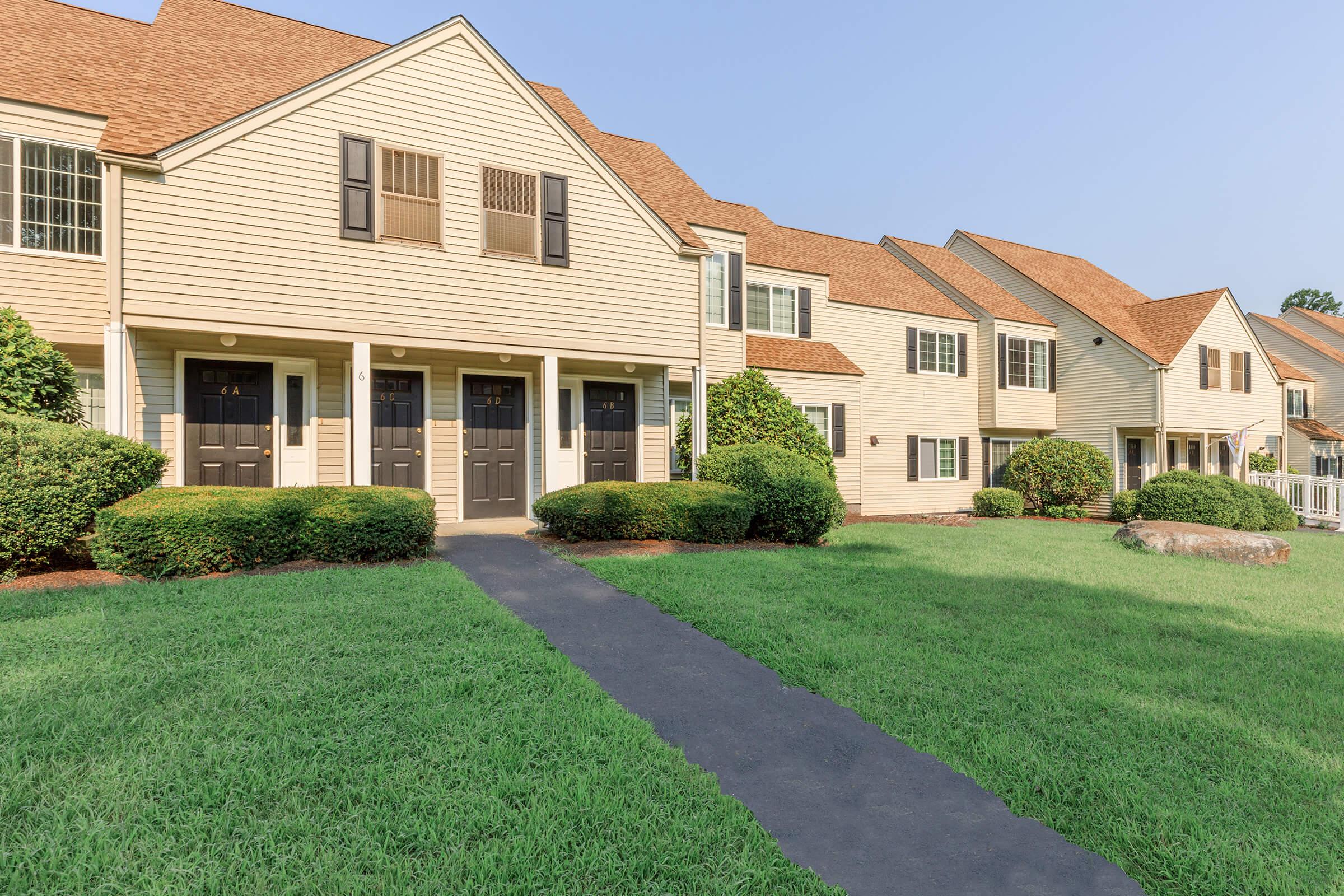 a large brick building with green grass in front of a house