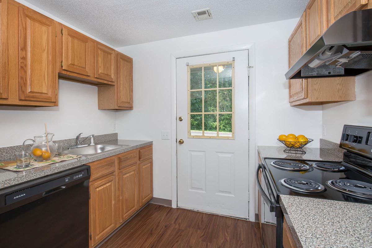 a kitchen with wooden cabinets and a wood floor