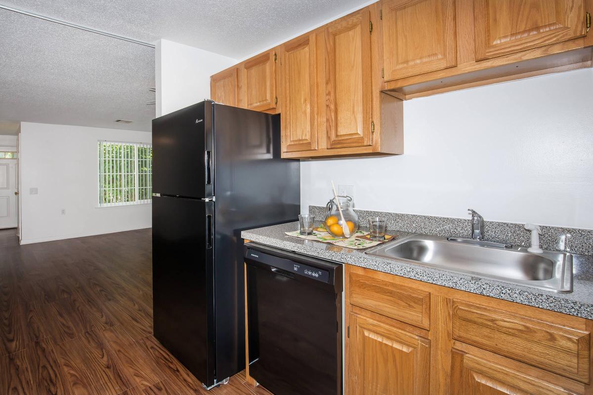 a large kitchen with stainless steel appliances and wooden cabinets