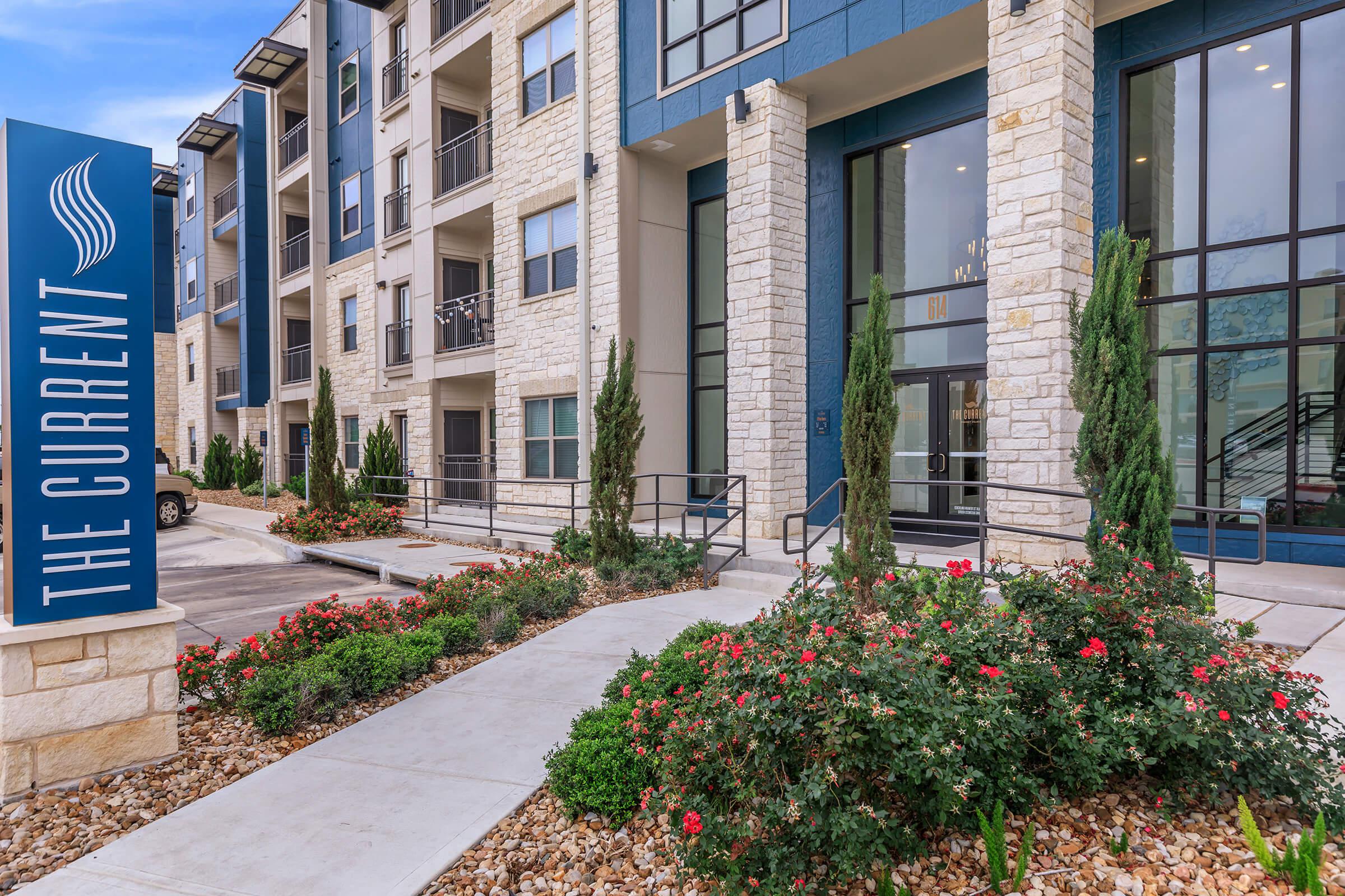 a close up of a flower garden in front of a building