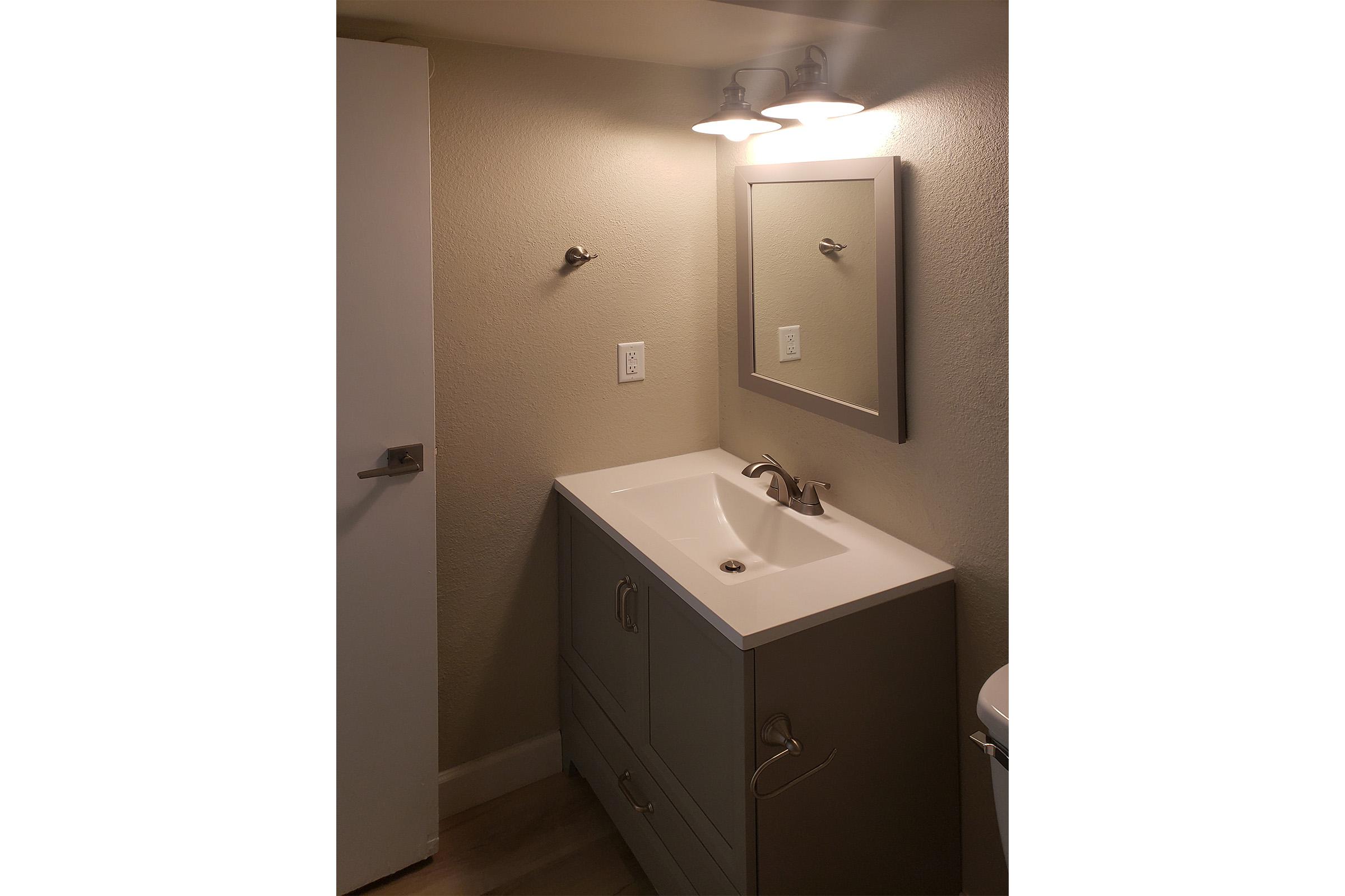 a brown speaker with a sink and a mirror