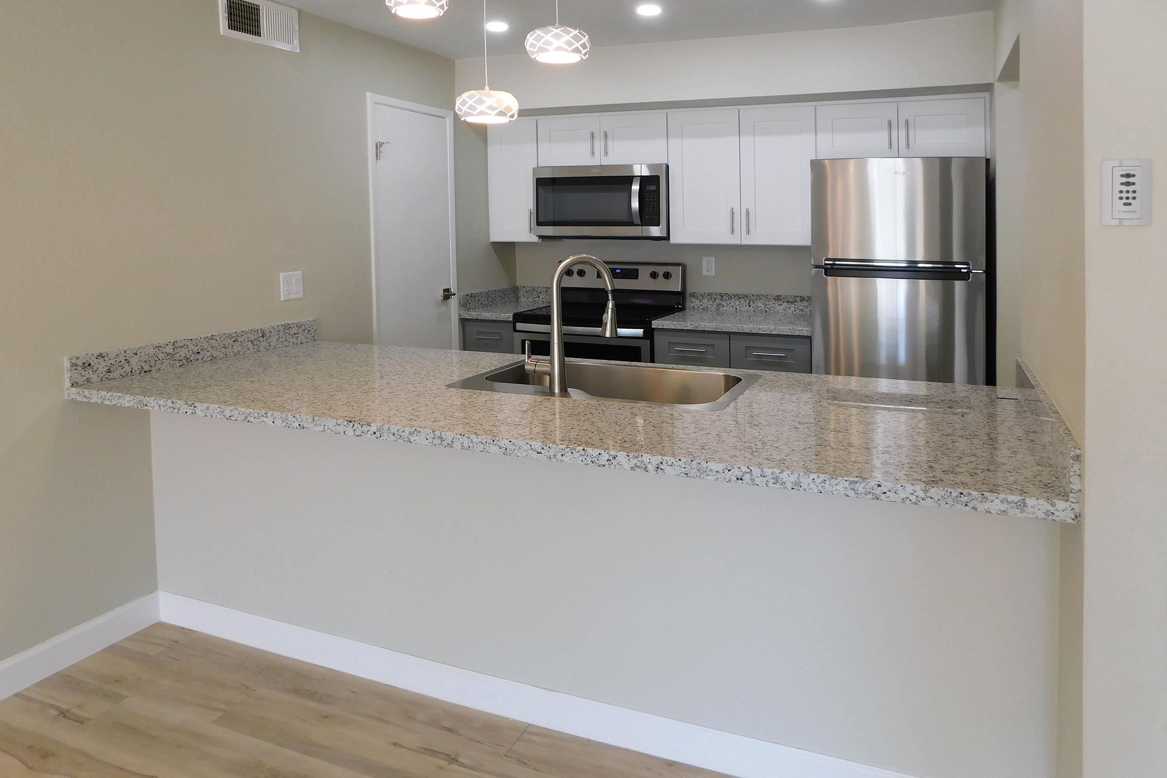 a kitchen with a sink and a mirror