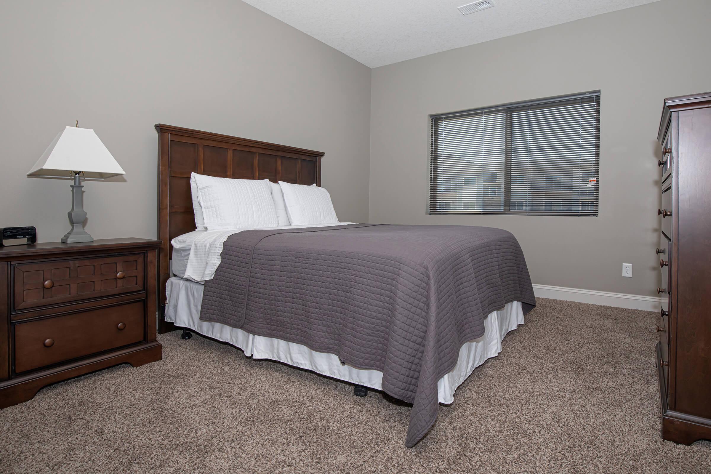 a bedroom with a bed and desk in a hotel room