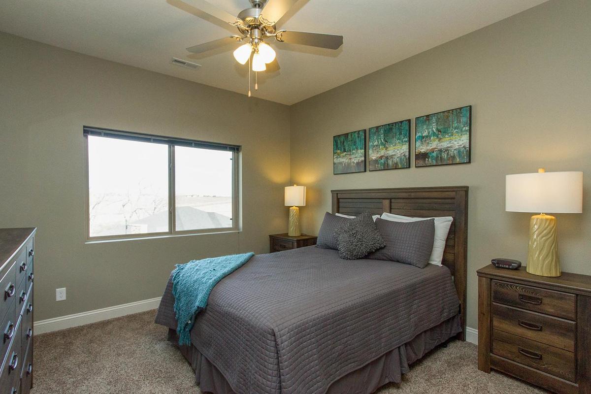 a bedroom with a bed and desk in a hotel room